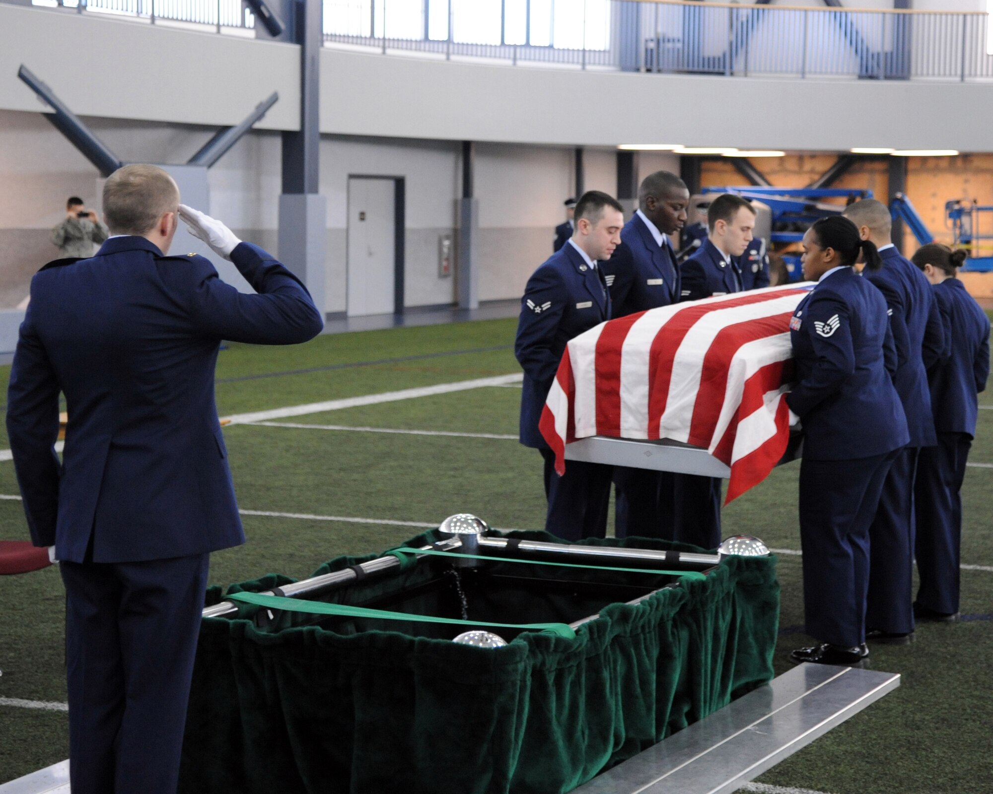 A member of the Eielson Air Force Base Honor Guard salutes a casket being carried to its notional resting place during a demonstration of an honor guard ceremony Feb. 17, 2012, at Baker Field House, Eielson Air Force Base, Alaska. The honor guard performs ceremonies at various events for Eielson, servicemembers, veterans and the local community. (U.S. Air Force photo/ Senior Airman Willard E. Grande II)