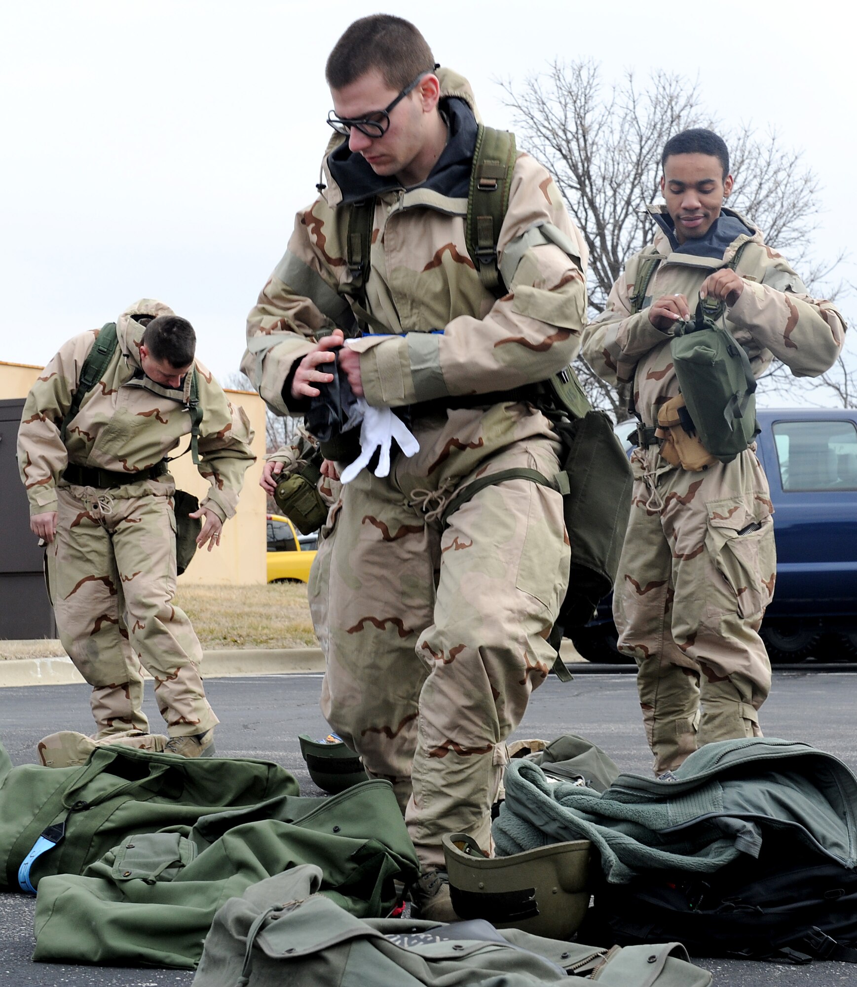 Airmen from Team Scott get into mission oriented protective posture gear during an Operational Readiness Exercise Feb 23, at Scott Air Force Base, Ill.  OREs are designed to test the base's ability to survive and operate in a deployed location. Scott is training for the upcoming Operational Readiness Inspection, which is expected to kick off June 2013. (U.S. Air Force photo/Airman 1st Class Divine Cox)