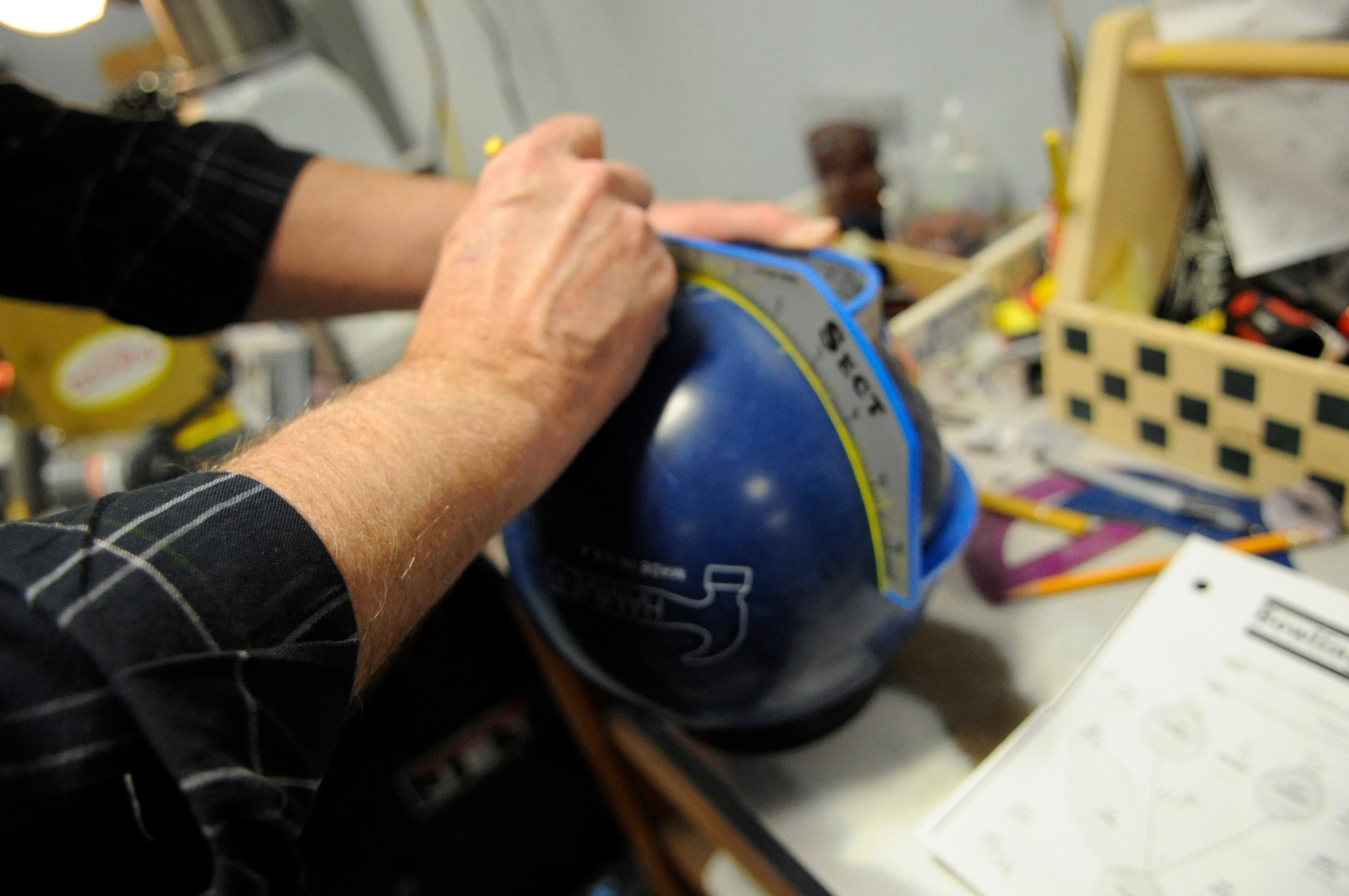 Bobby Choate, Barksdale Bowling Center manager, draws measurements onto a bowling ball before drilling finger holes at the bowling center on Barksdale Air Force Base, La., Feb. 22. The measurements are taken to ensure the owner's finger span fits the ball correctly. This can prevent tendon damage when bowling. (U.S. Air Force photo/Airman 1st Class Andrea F. Liechti)(RELEASED)