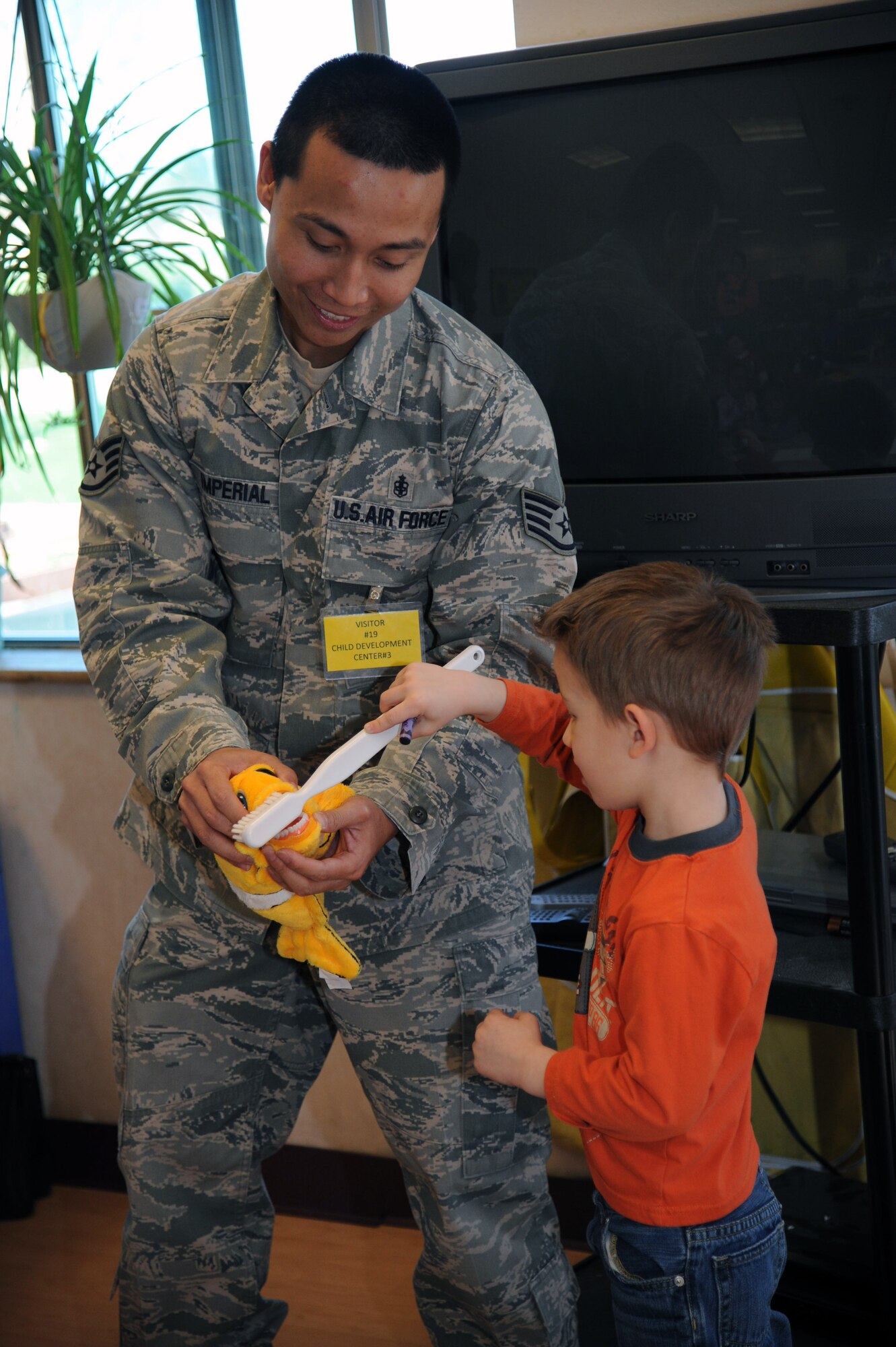 Evan Raffa, son of Master Sgt. Micheal Raffa, shows the class how to properly brush their teeth during a visit from the  60th DOS at the Child Development Center Feb. 16. (U.S. Air Force photo/Airman 1st Class Nicole Leidholm)