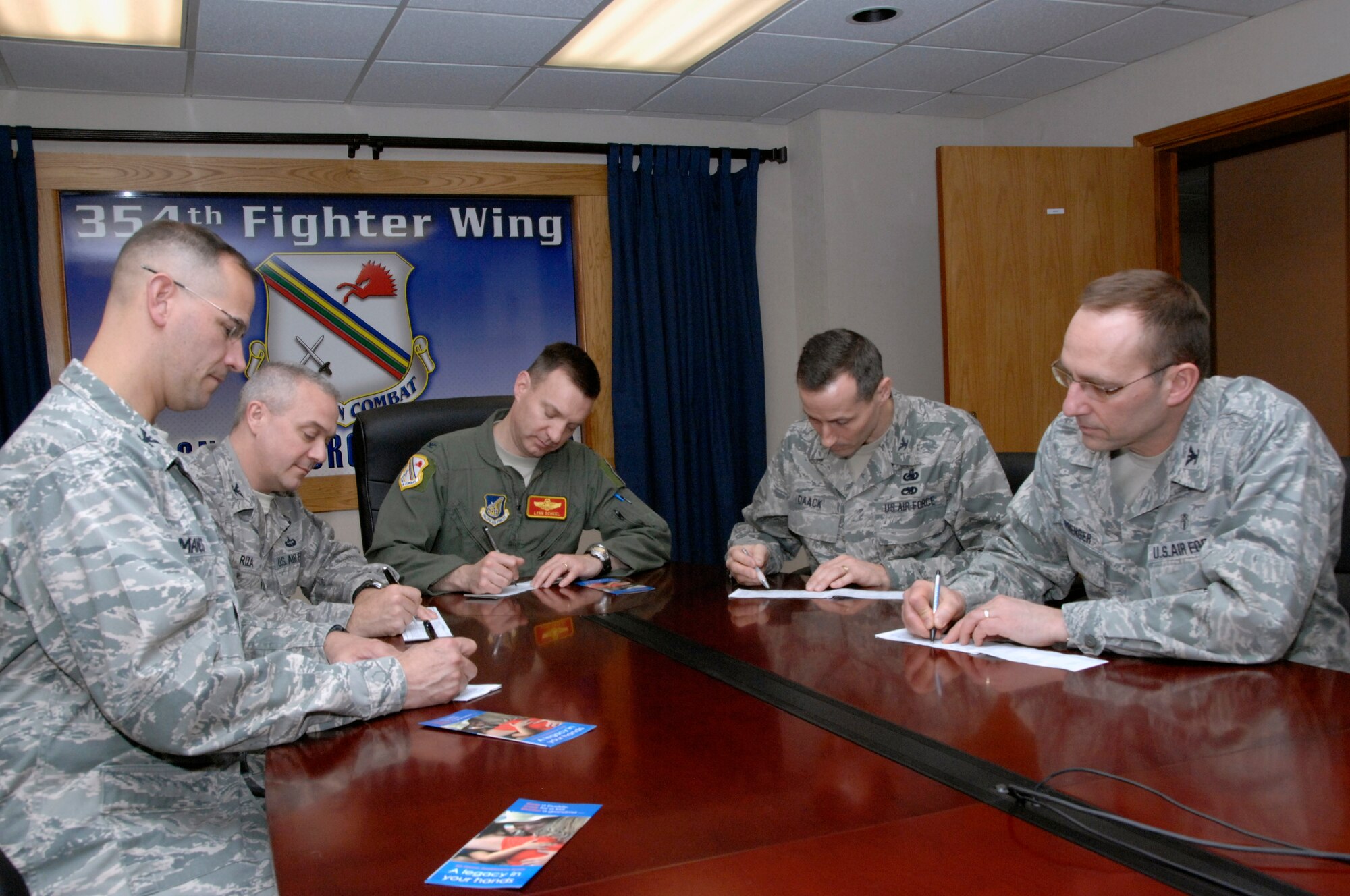 U.S. Air Force Cols. Bryan Manes, 354th Maintenance Group commander, Shane Riza, 354th Operations Group commander,  Lynn Scheel, 354th Fighter Wing vice commander, Thomas Daack, 354th Mission Support Group commander and Scott Sprenger, 354th Medical Group commander, pledge their support to the 39th Annual Air Force Assistance Fund during a meeting Feb. 15, 2012, Eielson Air Force Base, Alaska. AFAF provides Airmen an opportunity to contribute to multiple charities directly impacting other Airmen. The campaign, which runs March 5 through April 13, allows Airmen to support the Air Force Aid Society, Air Force Village Foundation, General and Mrs. Curtis E. LeMay Foundation and Air Force Enlisted Village.  (U.S. Air Force photo/Master Sgt. Jason Vaught)