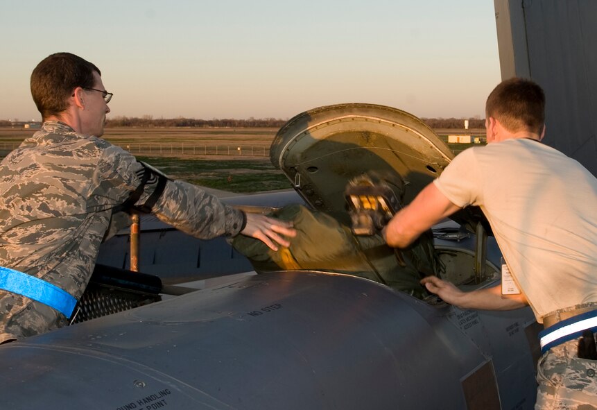 Tech. Sgt. Jeremy Wetzel and Senior Airman John Cox, 20th Aircraft Maintenance Unit, load a chute bag into a B-52H Stratofortress on Barksdale Air Force Base, La., Feb. 22. The chute bag contains the large parachute that is used to slow down a rapidly moving aircraft during landing. (U.S. Air Force photo/Airman 1st Class Benjamin Gonsier)(RELEASED)