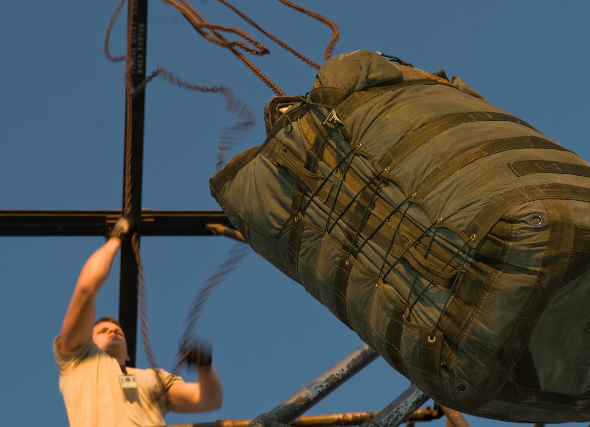 Senior Airman John Cox, 20th Aircraft Maintenance Unit, lifts a chute bag on Barksdale Air Force Base, La., Feb. 22. The chute bag weighs 185 pounds and requires a pulley in order to pull it up to the top of the stand. (U.S. Air Force photo/Airman 1st Class Benjamin Gonsier)(RELEASED)