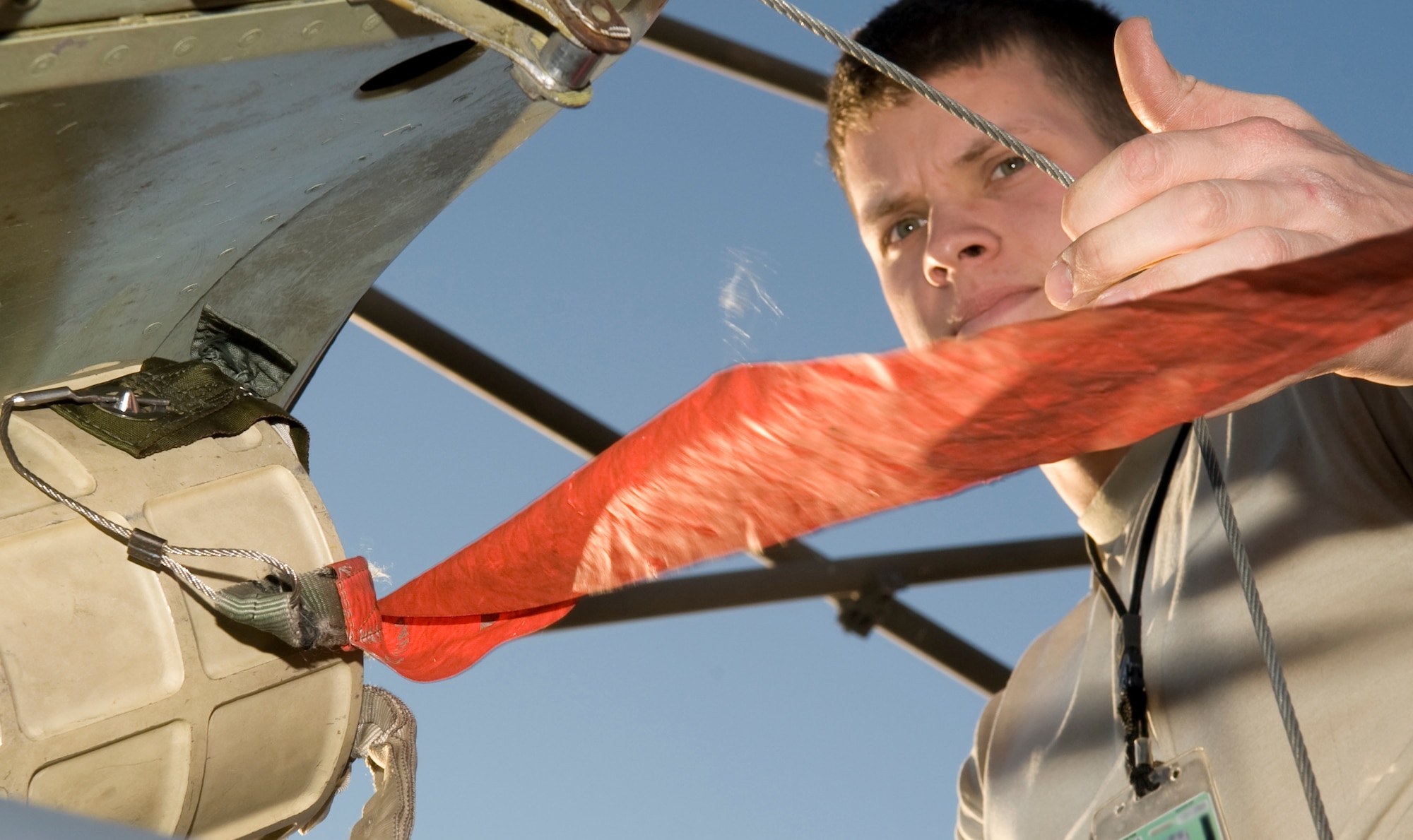 Senior Airman John Cox, 20th Aircraft Maintenance Unit, ensures a pilot chute canister is properly connected to the bottom of a drogue chute hatch on Barksdale Air Force Base, La., Feb. 22. A drogue parachute is used on rapidly moving vehicles and aircraft to help slow it down. (U.S. Air Force photo/Airman 1st Class Benjamin Gonsier)(RELEASED)