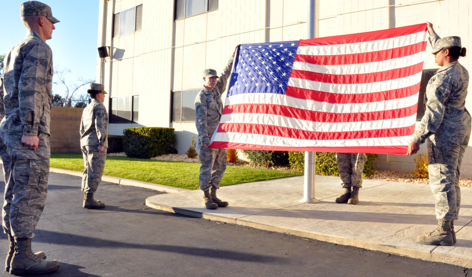 Presenting the flag to the class prior to flag folding.(left to right) Senior Airmen John Tullos 60th Operations Support Squadron student squadron commander, Staff Sgt. Katelyn Blundell 22nd Airlift Squadron, flag detail commander, Senior Airman Jason Horn 60th Dental Squadron, left halyardsman presenting the union, Senior Airmen Christopher Dixon 60th Medical Operations Squadron, right halyardsman only legs showing under the flag and Senior Airmen Chante Jackson 60th Medical Support Squadron, flag catcher presenting the stripes. (U.S. Air Force photo/Staff Sgt. Patrick Harrower)
