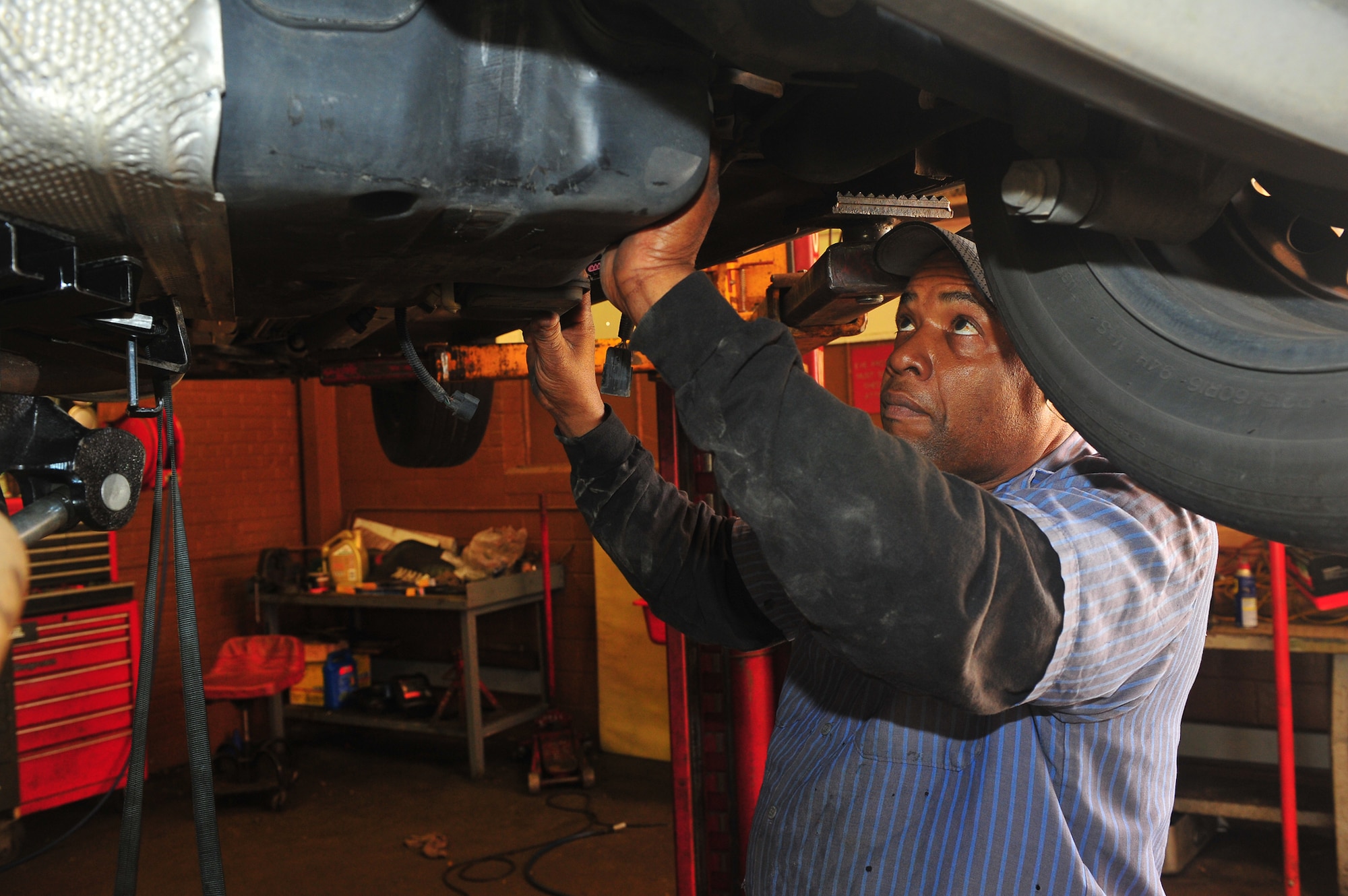 Will Young, auto hobby shop mechanic, installs a fuel tank on a customer?s vehicle after replacing the fuel pump on Barksdale Air Force Base, La., Feb. 23. Young and the other employees of the shop will be moving to a new auto hobby shop facility in March. (U.S. Air Force photo/Tech. Sgt. Mike Andriacco)(RELEASED)