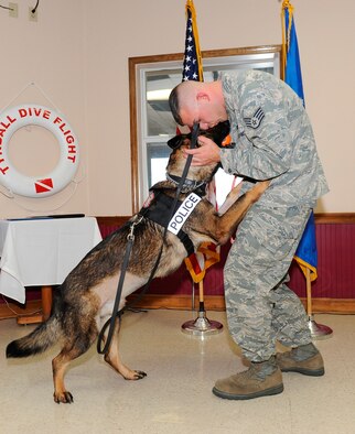 Staff Sgt. Brandon Rimmer, 325th Security Forces Squadron military working dog handler, shows some affection to his partner Dak Kilo-444 at Dak’s retirement ceremony Feb. 15, 2012. (U.S. Air Force photo by Lisa Norman)