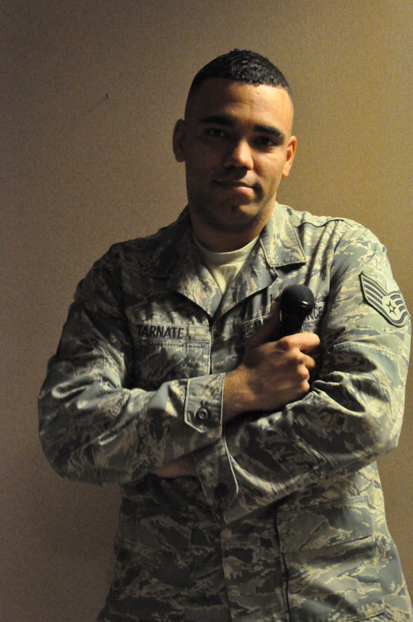 Staff Sgt. Joseph Tarnate, 660th Aircraft Maintenance Squadron communication navigation technician, poses with a microphone after singing "Happy Birthday" Feb. 16 to a coworker. Tarnate is one of 35 Airmen selected to tour with the Tops in Blue, the Air Force entertainment group. (U.S. Air Force photo/Airman 1st Class Madelyn Ottem)