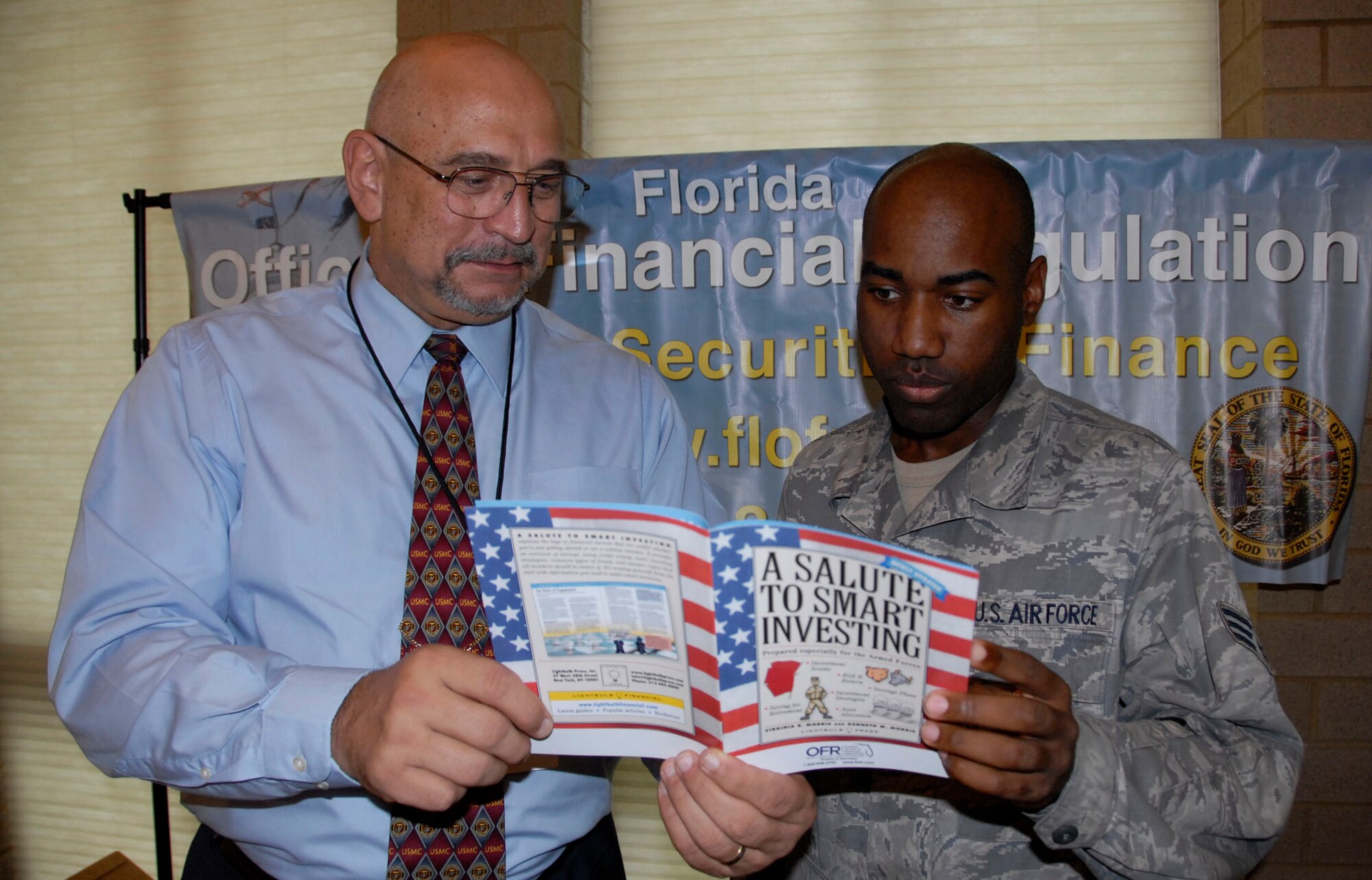 Ronn Hoover, the Florida Office of Financial Regulation area financial manager, offers information to Senior Airman Gregory Hurd, a member of the 33rd Fighter Wing, at the financial fitness expo at Eglin Air Force Base, Fla., Feb. 23.  More than 15 local agencies were on hand to heighten Eglin personnel’s financial awareness and knowledge with booklets, pamphlets, advice and giveaways.  (U.S. Air Force photo/Kevin Gaddie) 