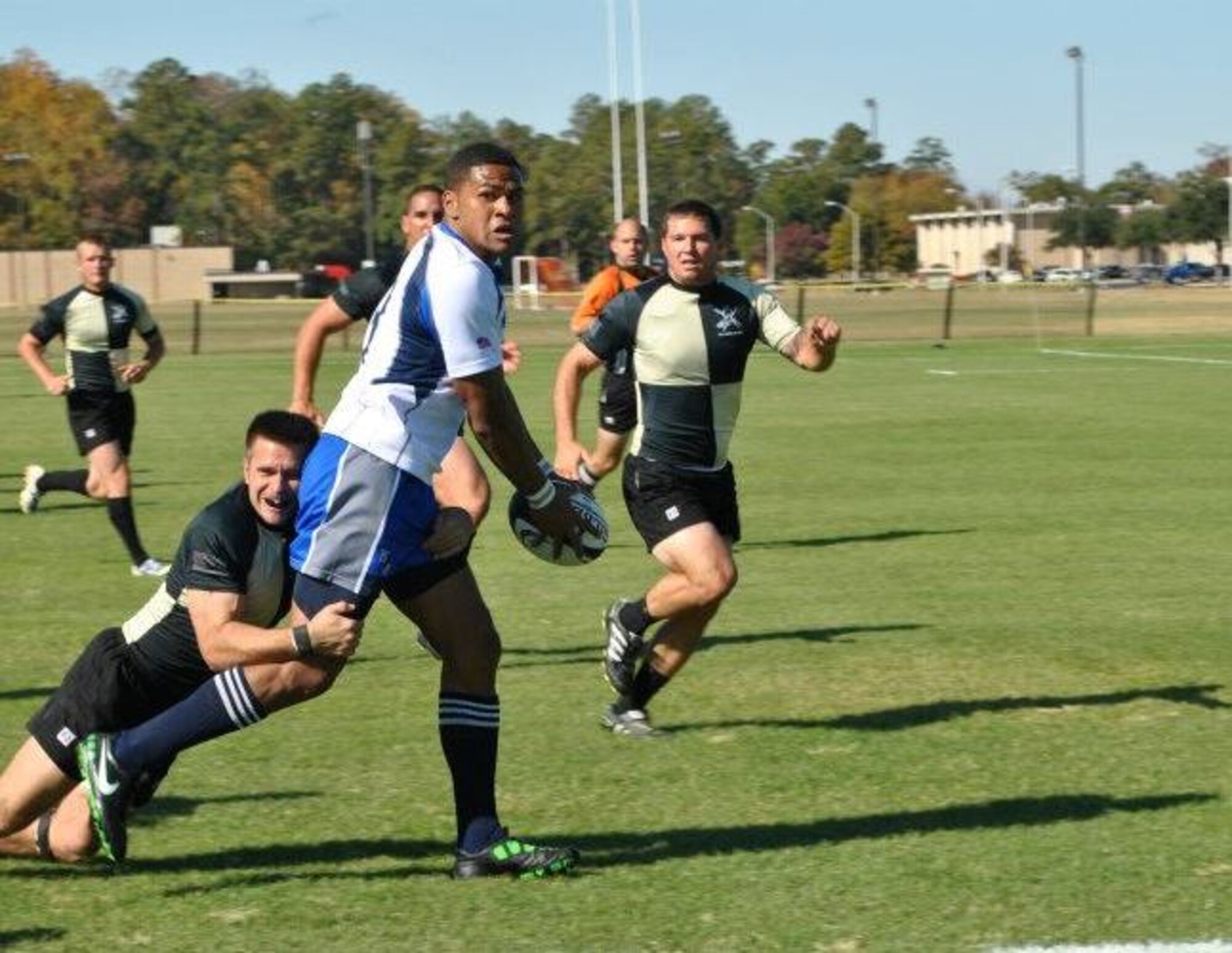 Senior Airman Marcus Satavu, 325th Air Control Squadron pilot simulator, handles the ball in a Rugby match of the Air Force versus the Army. (U.S. Air Force courtesy photo)