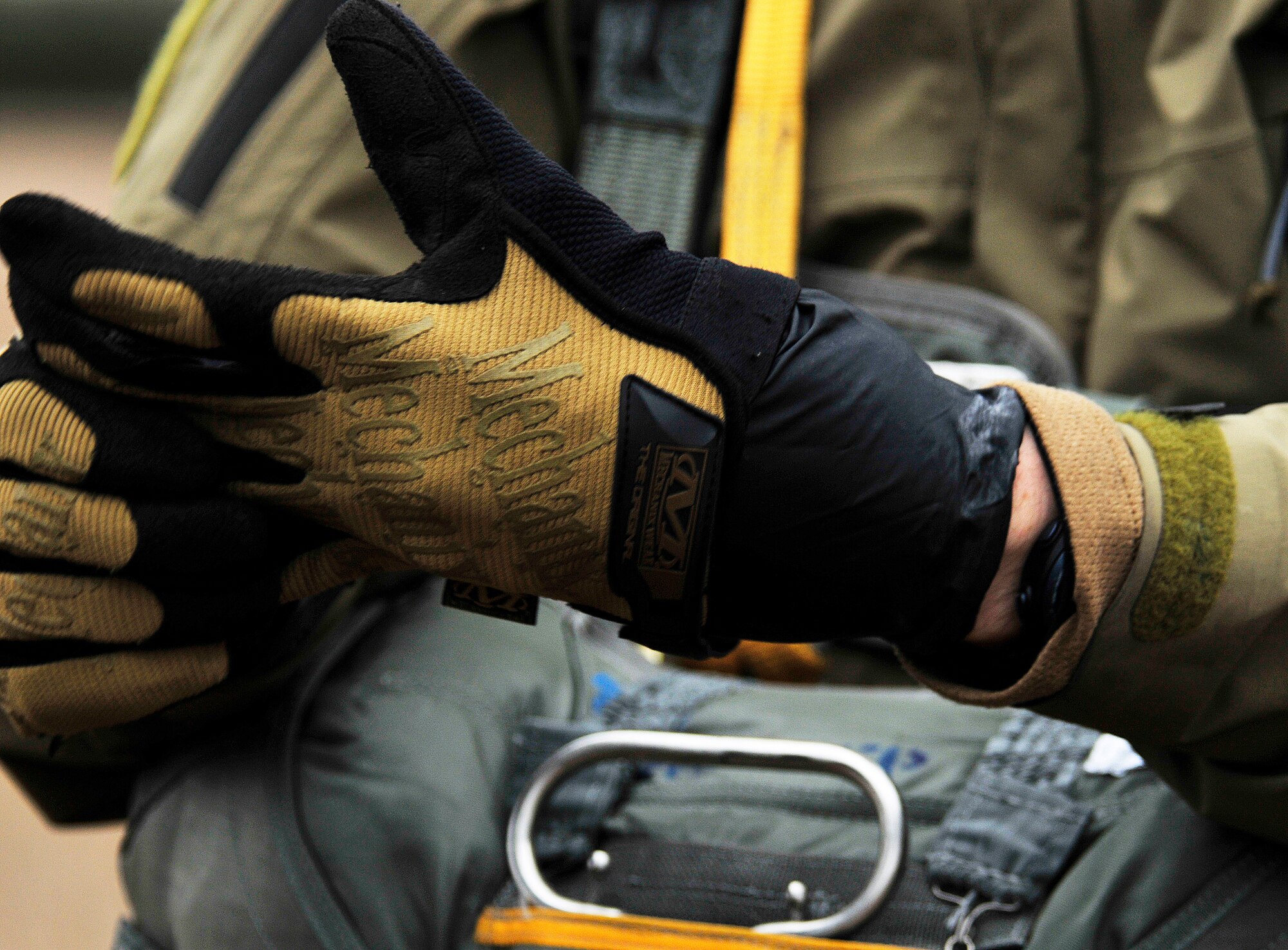 STANFORD TRAINING AREA, England – Staff Sgt. Joshua Kruse, 56th Rescue Squadron pararescueman, dons gloves in preparation for his static line jump Feb. 15, 2011. The pararescuemen were performing static line jumps, which involves a mechanism that opens a parachute automatically with no action required by the passenger. This is the first time that the 56th RQS has performed static line jumps since being stationed at Royal Air Force Lakenheath. (U.S. Air Force photo by Senior Airman Tiffany M. Deuel)