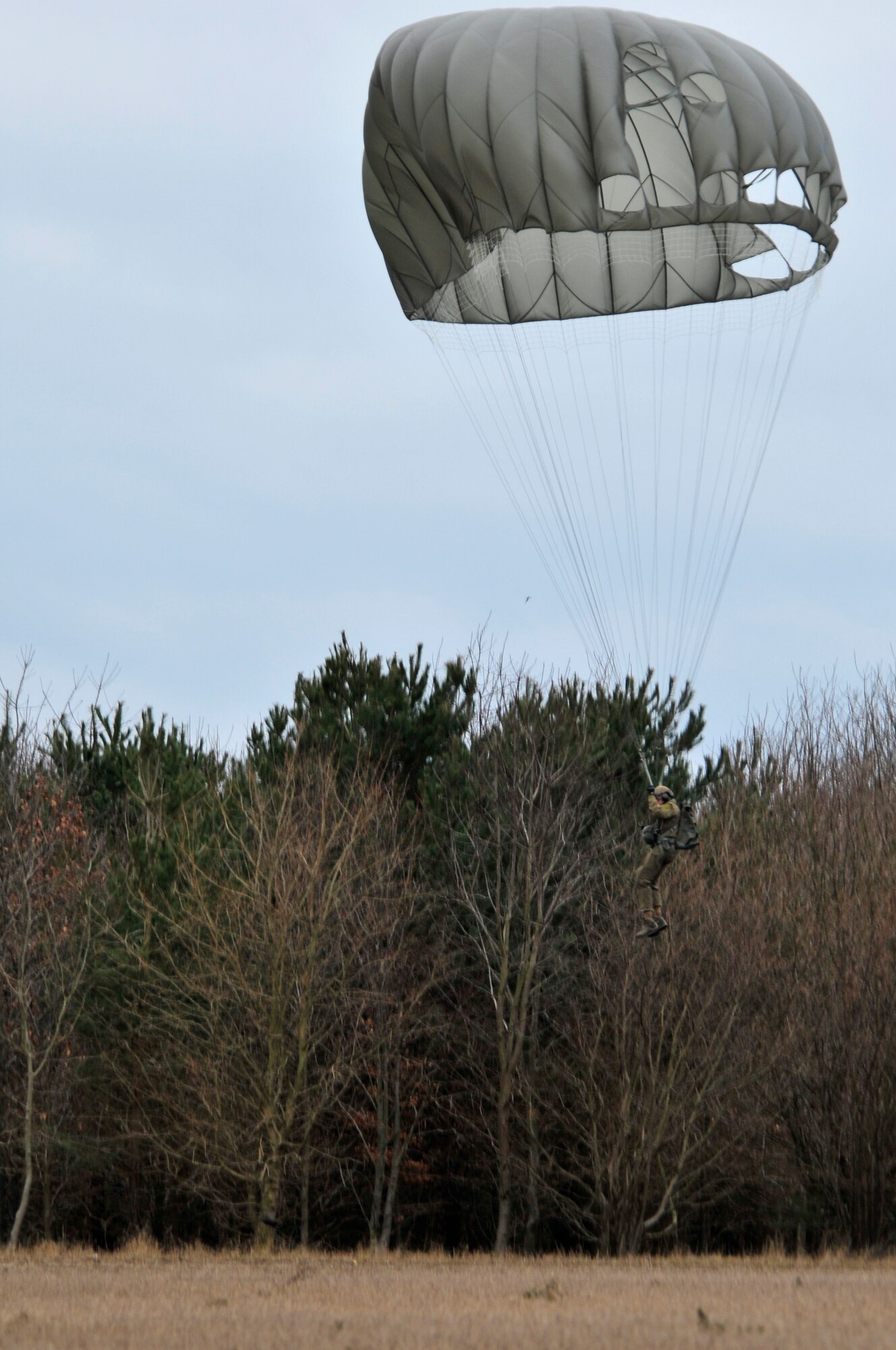 STANFORD TRAINING AREA, England – A pararescueman from the 56th Rescue Squadron parachutes out of an HH-60G Pave Hawk and lands Feb. 15, 2011. The pararescuemen were performing static line jumps, which involves a mechanism that opens a parachute automatically with no action required by the passenger. This is the first time that the 56th RQS has performed static line jumps since being stationed at Royal Air Force Lakenheath. (U.S. Air Force photo by Senior Airman Tiffany M. Deuel)