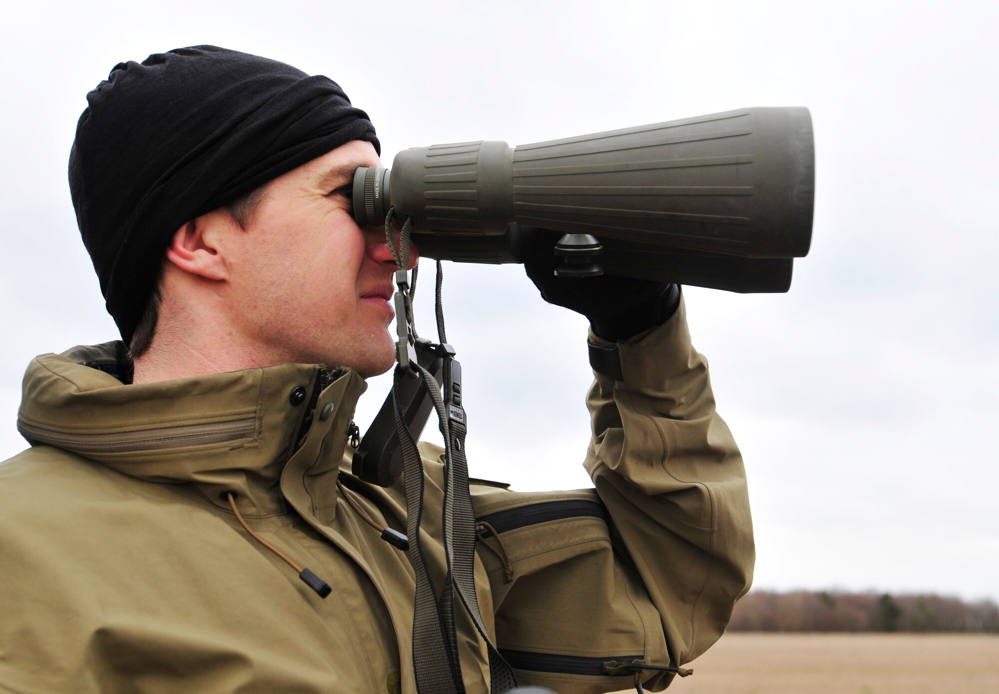 STANFORD TRAINING AREA, England – Staff Sgt. Joshua Kruse, 56th Rescue Squadron pararescueman, uses binoculars to locate an HH-60G Pave Hawk Feb. 15, 2011. The pararescuemen were performing static line jumps, which involves a mechanism that opens a parachute automatically with no action required by the passenger. This is the first time that the 56th RQS has performed static line jumps since being stationed at Royal Air Force Lakenheath. (U.S. Air Force photo by Senior Airman Tiffany M. Deuel)