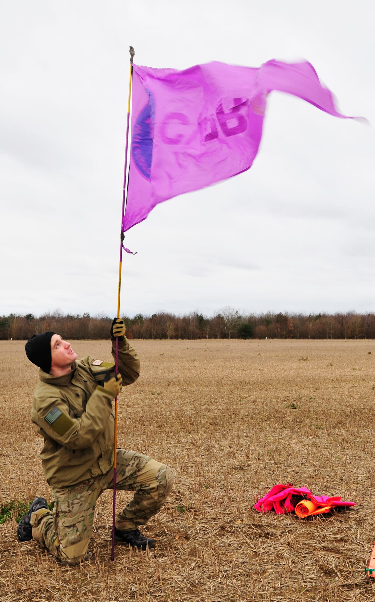 STANFORD TRAINING AREA, England – Staff Sgt. Joshua Kruse, 56th Rescue Squadron pararescueman, sets up a wind directional arrow Feb. 15, 2011. Knowing the direction of the wind helps pararescuemen in the air know how to direct their parachutes to the drop zone. The pararescuemen were performing static line jumps, which involves a mechanism that opens a parachute automatically with no action required by the passenger. This is the first time that the 56th RQS has performed static line jumps since being stationed at Royal Air Force Lakenheath. (U.S. Air Force photo by Senior Airman Tiffany M. Deuel)