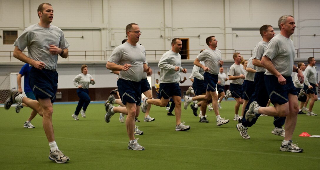 Commanders, chiefs and first sergeants from across the installation warm up for a physical training session in the Pride Hangar at Ellsworth Air Force Base, S.D., Feb. 17, 2012. Ellsworth leadership epitomized the term “lead by example” by completing a circuit of challenging exercises created and led by a group of physical training leaders from the 28th Medical Group. (U.S. Air Force photo by Airman 1st Class Kate Thornton/Released)