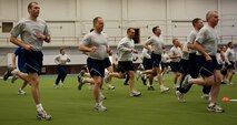 Commanders, chiefs and first sergeants from across the installation warm up for a physical training session in the Pride Hangar at Ellsworth Air Force Base, S.D., Feb. 17, 2012. Ellsworth leadership epitomized the term “lead by example” by completing a circuit of challenging exercises created and led by a group of physical training leaders from the 28th Medical Group. (U.S. Air Force photo by Airman 1st Class Kate Thornton/Released)