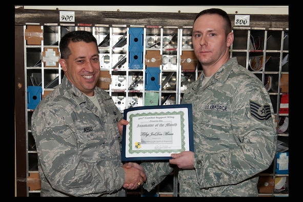 RAF ALCONBURY, United Kingdom - Col. Brian Kelly, 501st Combat Support Wing commander, presents the Innovator of the Month Award to Tech. Sgt. JoeDon Messer, 423rd Communications Squadron. Messer created a postal tracking program that saved the Department of Defense $2,200 and implemented tracking procedures that reduced 132 man hours a year. (U.S. Air Force photo by Senior Airman Joel Mease) 