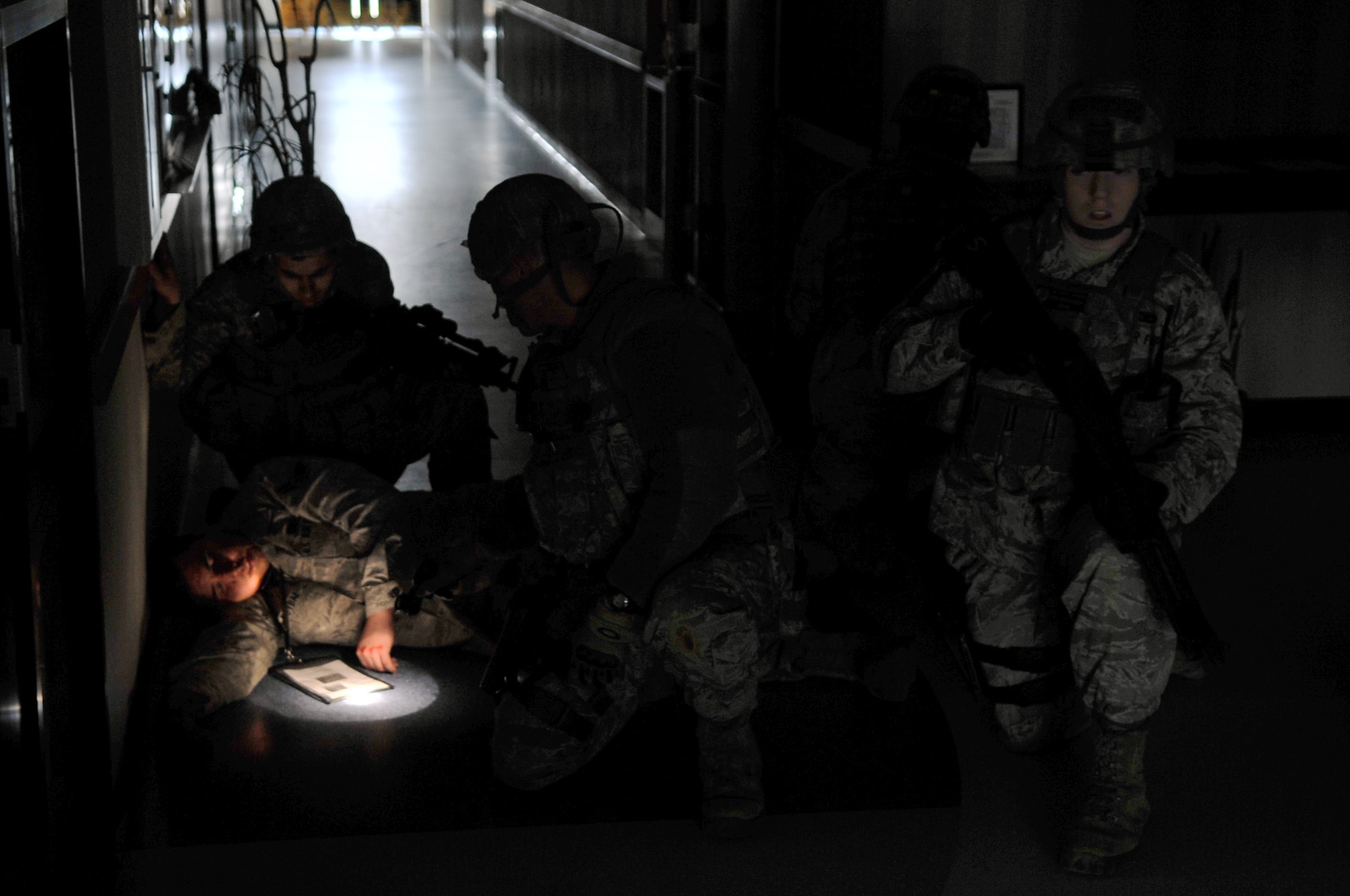 51st Security Forces Squadron Airmen check on a wounded individual during an Emergency Management Exercise here, Feb. 22, 2012. The EME practiced the roles and precautions of a potential active shooter scenario.  (U.S. Air Force photo/Staff Sgt. Craig Cisek) 