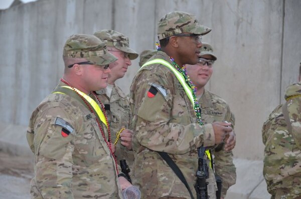 AFGHANISTAN — Soldiers watch and catch beads as the U.S. Army Corps of Engineers Afghanistan Engineer District-South Mardi Gras parade passes by on Kandahar Airfield here, Feb. 21, 2012. 