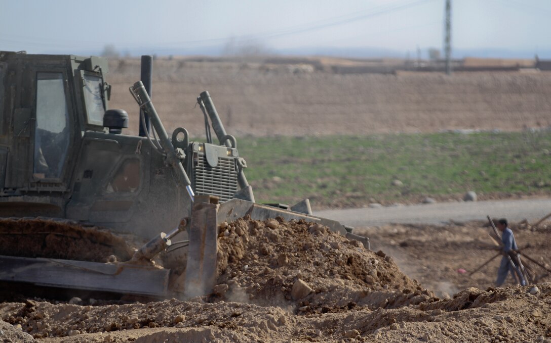 A 3rd Combat Engineer Battalion bulldozer flattens rubble to give the Afghan National Civil Order Police a better view of the surrounding area, Feb. 23. Marines with 3rd CEB demolished half of the patrol base here, and worked with the ANCOP to build new walls.