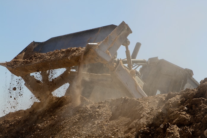 A 3rd Combat Engineer Battalion bulldozer moves dirt to reinforce a newly built wall, Feb. 23. The battalion tore down or reduced more than 12 patrol bases during the last months. With fewer men stationed in the area, the need to scale down bases was a primary mission for 3rd CEB.