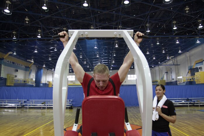 Pfc. Dylan Hale, Headquarters and Headquarters Squadron postal clerk, does pull-ups while competing in the Commander’s Cup Mystery Endruance Challenge in the IronWorks Gym sports court here Feb. 24. The mystery challenges consisted of surrenders, dips, ab-wheel rolls, bosu burpees with shoulder press, box jumps, pull-ups and suspended alternated lunges. Each participant had two minutes to do AS MANY repetitions as possible.