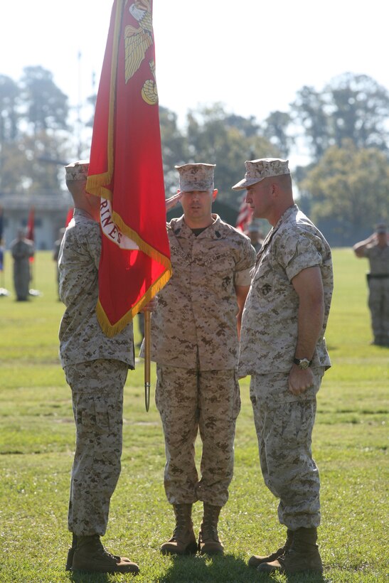 Lt. Col. David Hudspeth, former commanding officer for 3rd Battalion 9th Marine Regiment, 2nd Marine Division, and Lt. Col. Carl Cooper, incoming commanding officer for 3/9, exchange the colors during a change of command ceremony while Sgt. Maj. Jeffrey Monssen, 3/9 battalion sergeant major, salutes, Oct. 21. During the ceremony, 3/9 bid farewell to Lt. Col. David Hudspeth and welcomed Lt. Col. Carl Cooper.