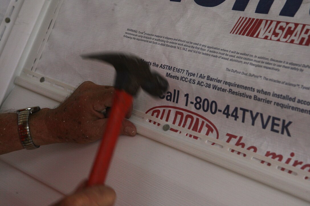 A volunteer nails vinyl siding into the house of Eric and Cheryl LeClair’s house during the Military Missions In Action build in Swansboro, N.C., Oct. 10. The LeClair’s house, in serious need of repair, was refurbished by volunteers from MMIA, Home Depot and Wellness for Warriors.