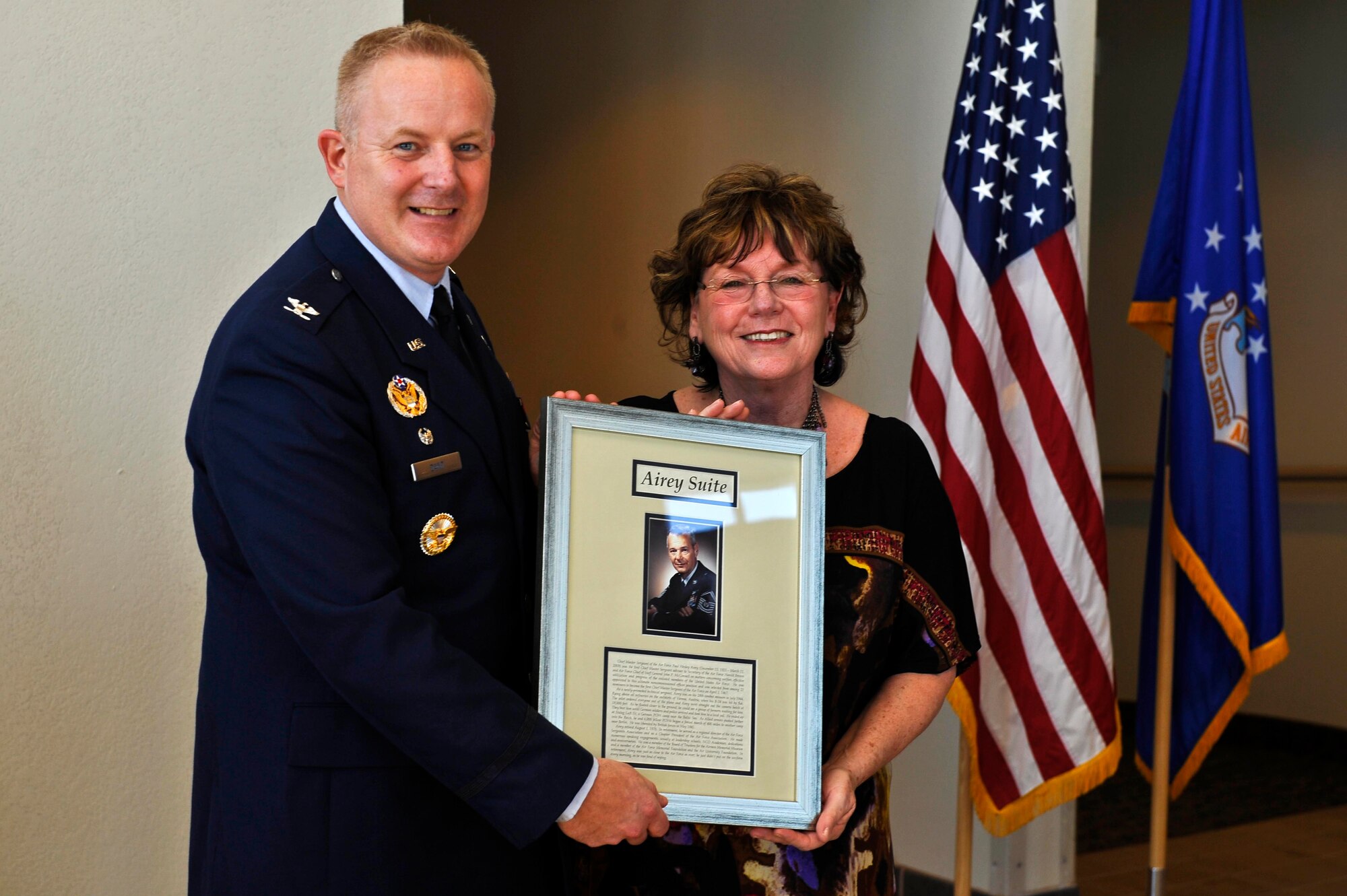 BUCKLEY AIR FORCE BASE, Colo.--  Colonel Daniel Dant, 460th Space Wing commander, presents a dedication plaque with Ellen Reid, daughter of the first Chief Master Sgt. of the Air Force, Paul W. Airey, Feb. 24, 2012. The dedication plaque will be displayed outside of the Airey Suite at the Rocky Mountain Lodge. (U.S. Air Force photo by Airman 1st Class Riley Johnson)
