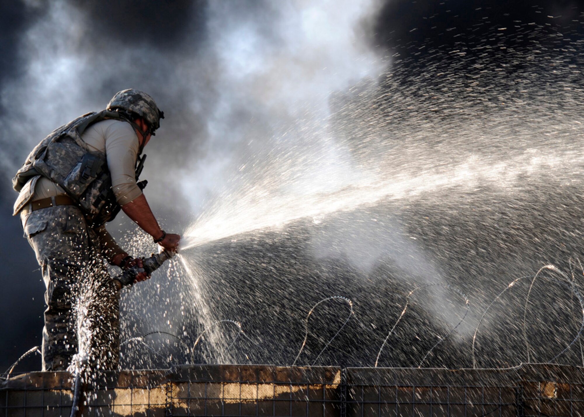 Fire fighting efforts during an attack by insurgent forces on Forwardard Operation Base Kalagush, Afghanistan, Dec. 28, 2010, are shown in this image by Senior Airman Chanise Epps of Provincial Reconstruction Team Nuristan. Epps documantation of the event earned her the Airman First Class Darryl G. Winters Combat Communication Award. (U.S. Air Force photo by Senior Airman Chanise Epps)