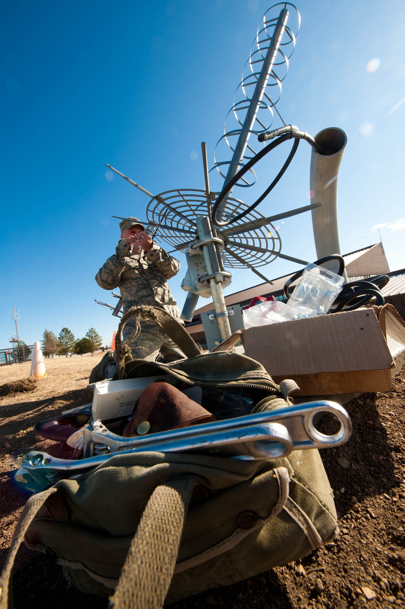 Master Sgt. James Shearer, 28th Communications Squadron transmission system radio maintainer, adjusts the reflector rim on a new antenna for the 28th Operations Support Squadron on Ellsworth Air Force Base, S.D., Feb. 13, 2012. The antenna reflector focuses beam signals into a single point to help direct the radiating signal back to the point of origin. (U.S. Air Force photo by Airman 1st Class Zachary Hada/Released)