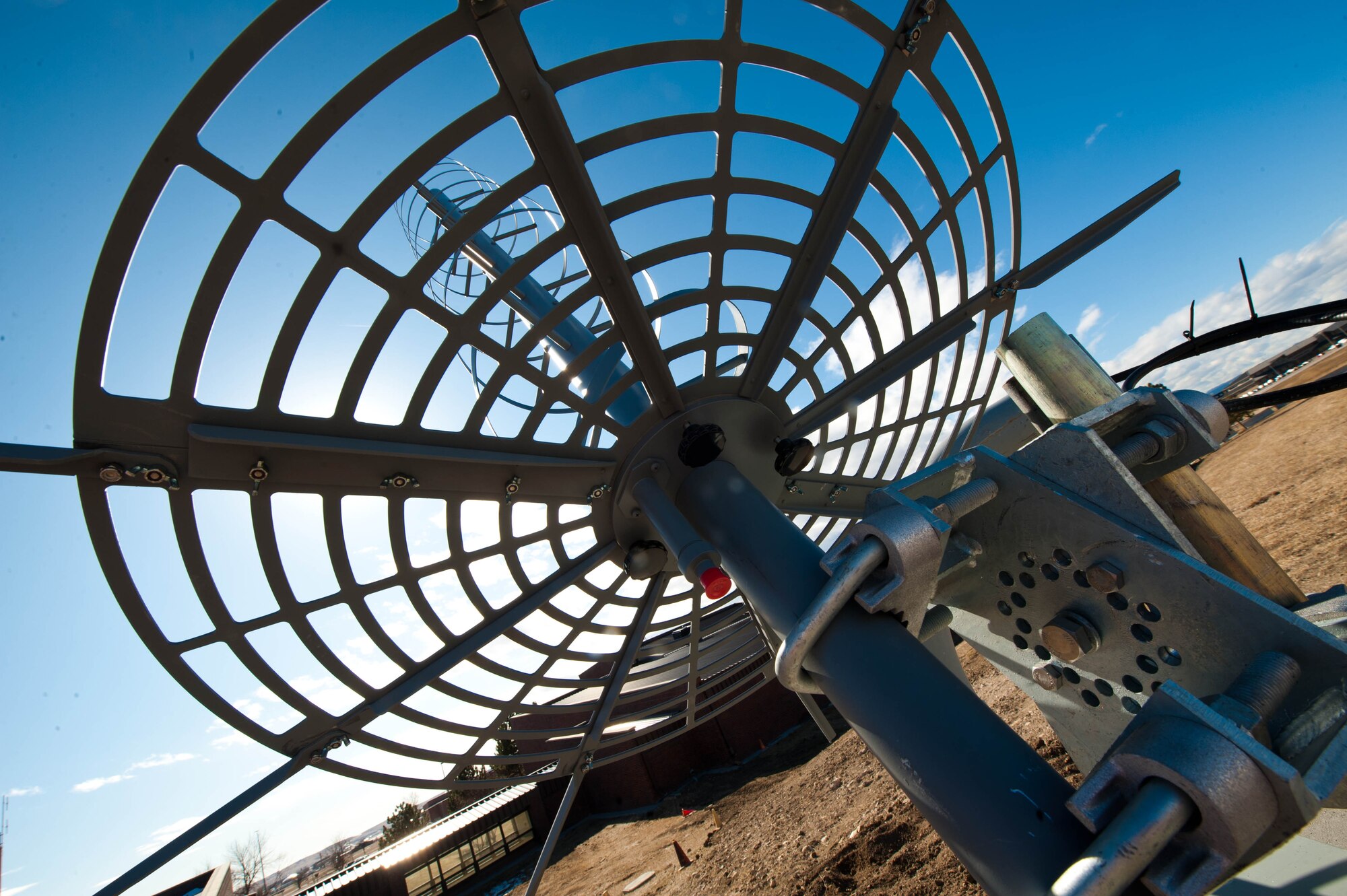 A new helical antenna is installed to replace a temporary antenna being used by the 28th Operation Support Squadron to provide optimal satellite communication capabilities at Ellsworth Air Force Base, S.D., Feb. 13, 2012. The helical antennas are built to withstand extreme weather conditions with dielectric rods along the mast, while the ground plane is backed with reinforcing ribs into which tubular axial rods are placed to increase the diameter of the ground plane. (U.S. Air Force photo by Airman 1st Class Zachary Hada/Released)