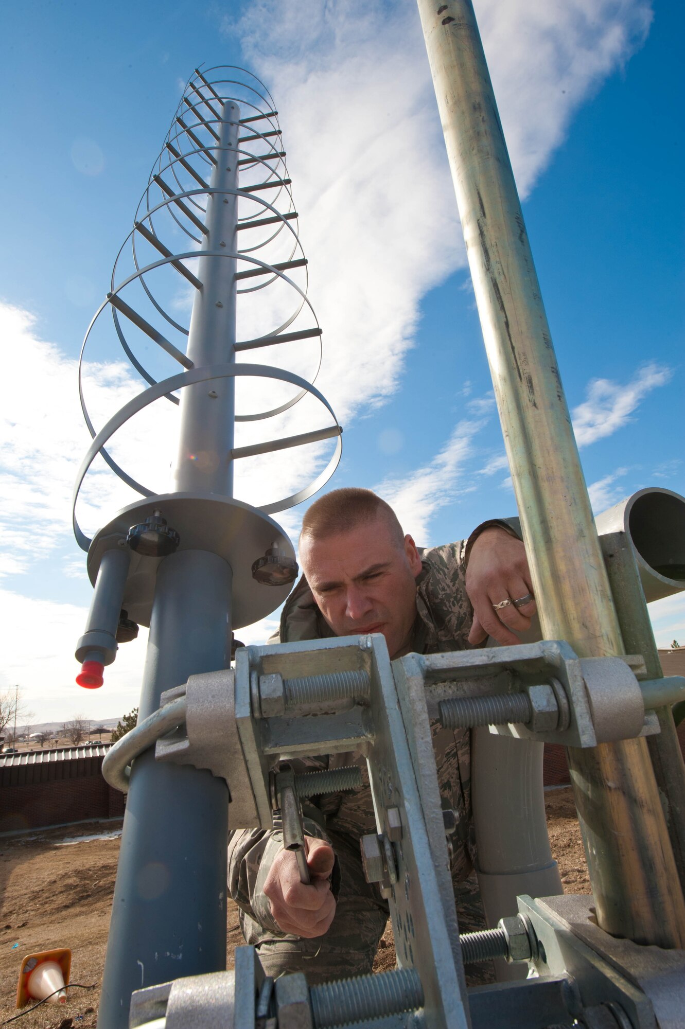 Master Sgt. James Shearer, 28th Communications Squadron transmission system radio maintainer, mounts and fastens a new helical antenna to a AM-1 mount used by the 28th Operations Support Squadron at Ellsworth Air Force Base, S.D., Feb. 13, 2012. The 28th OSS uses the antenna for joint range extension capabilities, to send and retrieve information via satellite. (U.S. Air Force photo by Airman 1st Class Zachary Hada/Released)
