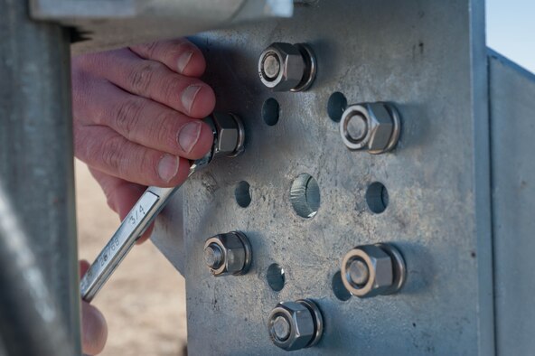 Master Sgt. James Shearer, 28th Communications Squadron transmission system radio maintainer, assembles an AM-1 antenna mount on Ellsworth Air Force Base, S.D., Feb. 13, 2012. The antenna mount must be angled precisely so the new helical antenna can properly send and receive satellite signals. (U.S. Air Force photo by Airman 1st Class Zachary Hada/Released)