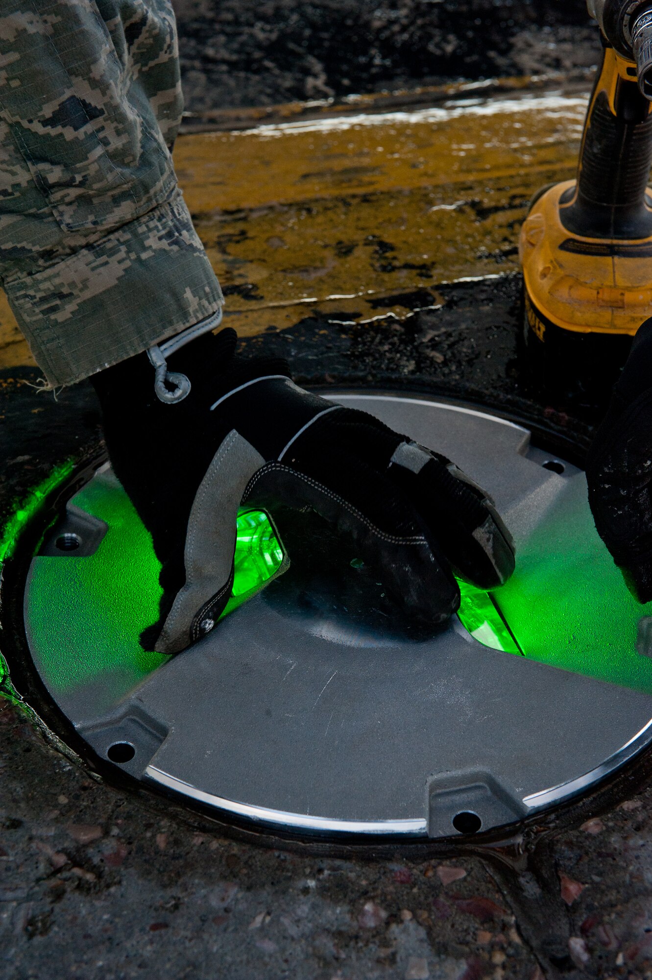 Staff Sgt. Evan Spitzer, 28th Civil Engineer Squadron electrical systems craftsman, installs a centerline light after repairing it on a taxiway on Ellsworth Air Force Base, S.D., Feb. 16, 2012. These lights to ensure aircrew can easily see and properly navigate the flightline. (U.S. Air Force photo by Airman 1st Class Kate Thornton/Released)