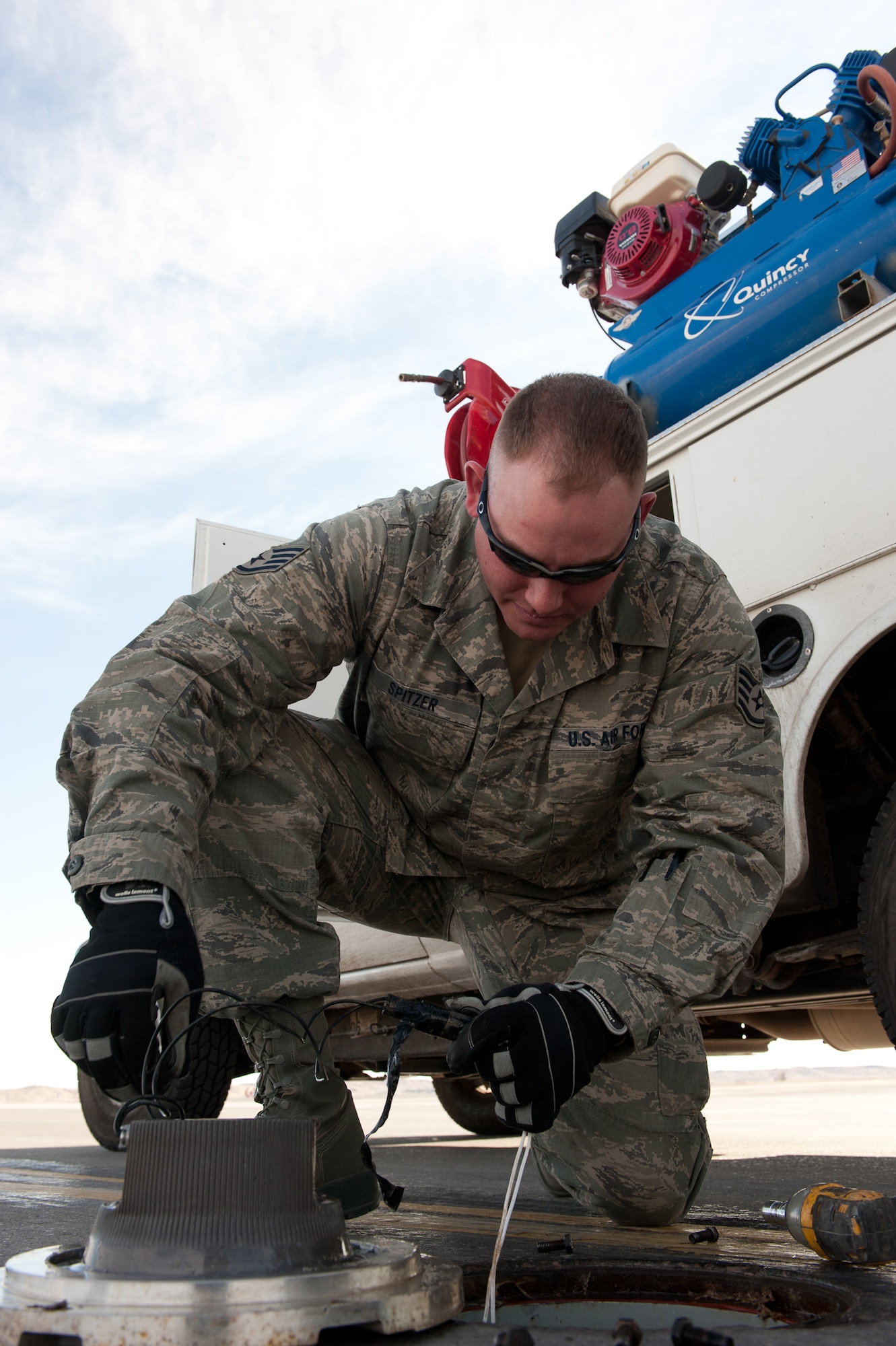 Staff Sgt. Evan Spitzer, 28th Civil Engineer Squadron electrical systems craftsman, disconnects a centerline light during maintenance on a taxiway at Ellsworth Air Force Base, S.D., Feb. 16, 2012. Fifty-five lights illuminate the Ellsworth flightline to give aircrews a visual reference during taxi. Airmen quickly respond to fix any broken lights to ensure the flightline remains illuminated. (U.S. Air Force photo by Airman 1st Class Kate Thornton/Released)