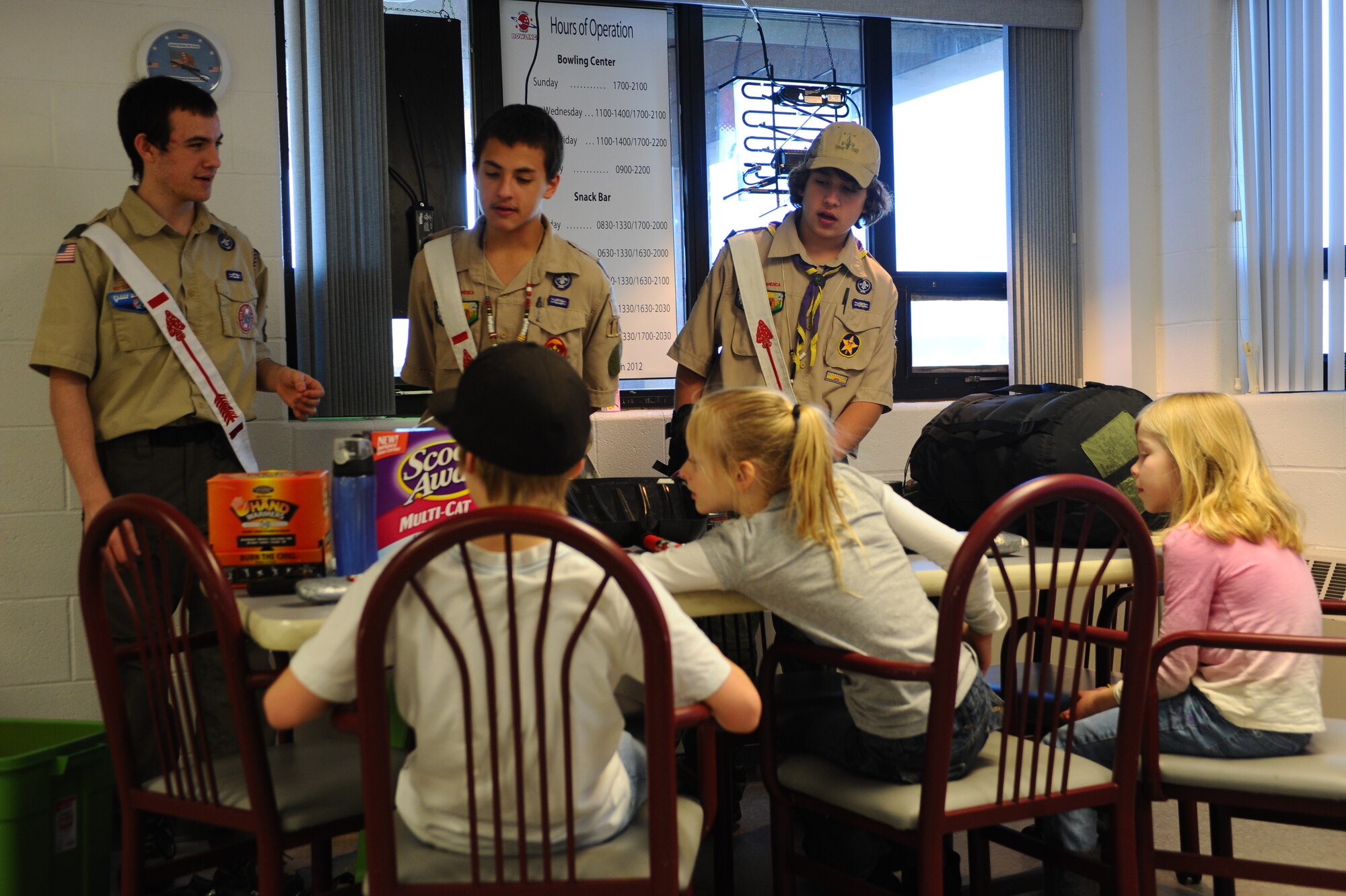 Boy scouts (from left) Caleb Tisher, Miccah Tisher, and Nathaniel Brown, teach cold weather survival training to children during the Snow Jam event hosted at the Bandit Lanes bowling alley on Ellsworth Air Force Base, S.D., Feb. 11, 2012. The Boy Scouts displayed survival kits and explained the importance of the items and what to do during emergency cold weather situations. (U.S. Air Force photo by Airman 1st Class Zachary Hada/Released)