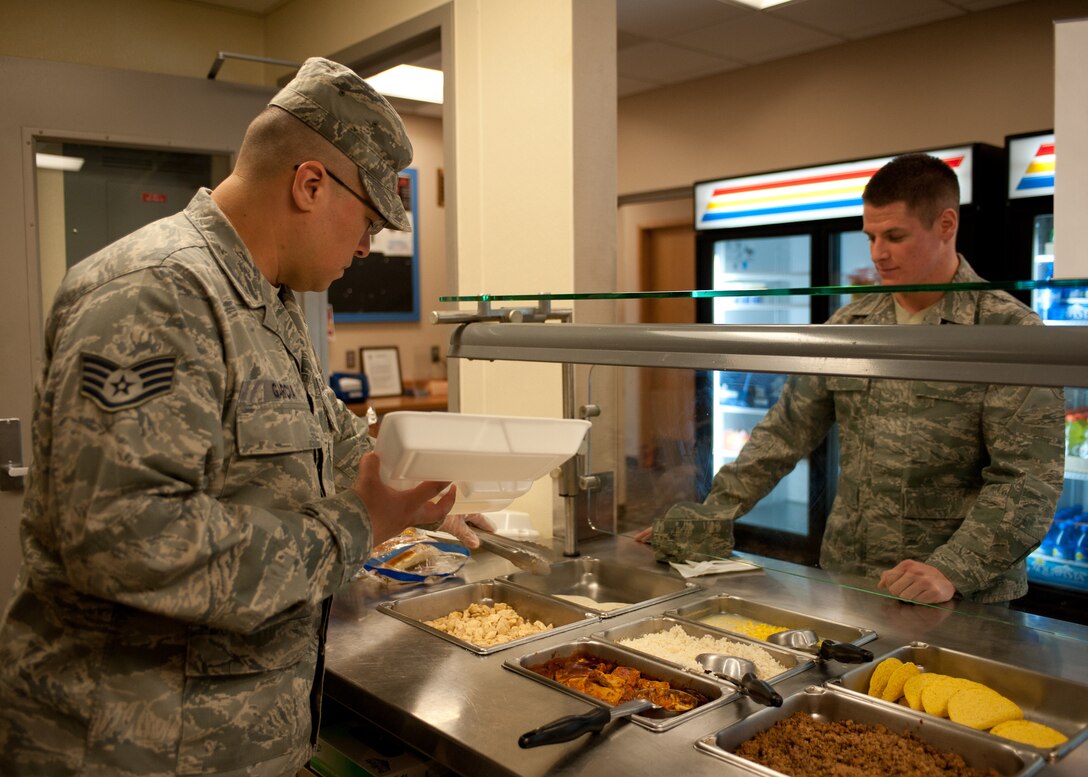 Staff Sgt. Raymond Garcia, 28th Force Support Squadron assistant manager of the flight kitchen, serves Airman 1st Class Collin Dunn, 28th Logistics Readiness Squadron fuels laboratory technician, at the flight kitchen on Ellsworth Air Force Base, S.D., Feb. 14, 2012. The flight kitchen operates 24 hours a day to provide hot meals and pre-made lunches to-go for Airmen across the 28th Bomb Wing. (U.S. Air Force photo by Airman Alystria Maurer/Released)