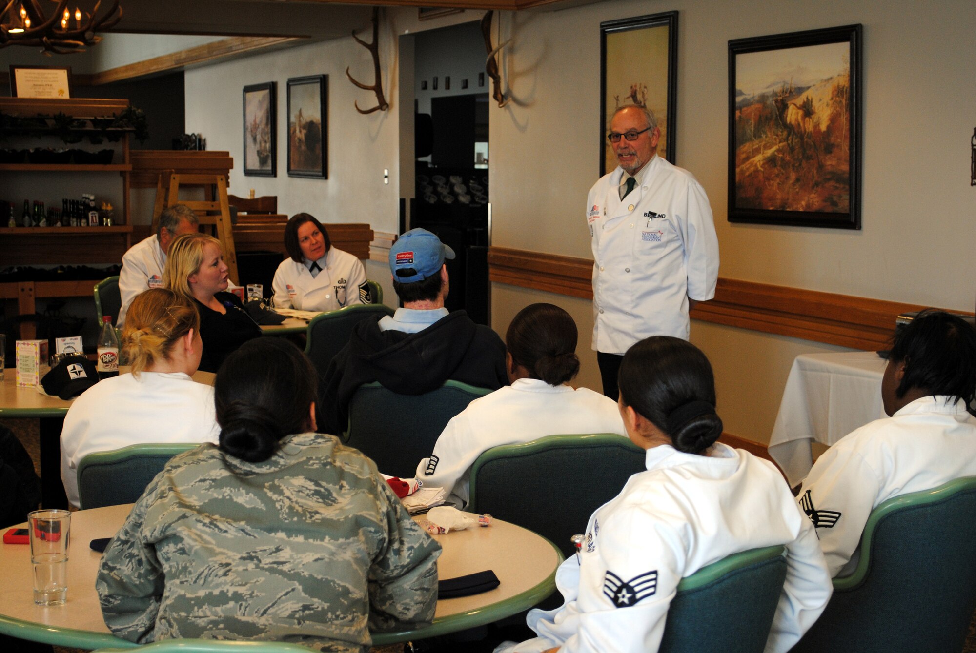 Jeff Berlind, a member of the National Restaurant Association, talks to Team Malmstrom members who operate the Elkhorn Dining Facility during a post-inspection gathering. Berlind is one of three members who evaluated the DFAC on various criteria in hopes of winning the Air Force-level Hennessy award.. (U.S. Air Force photo/Beau Wade)