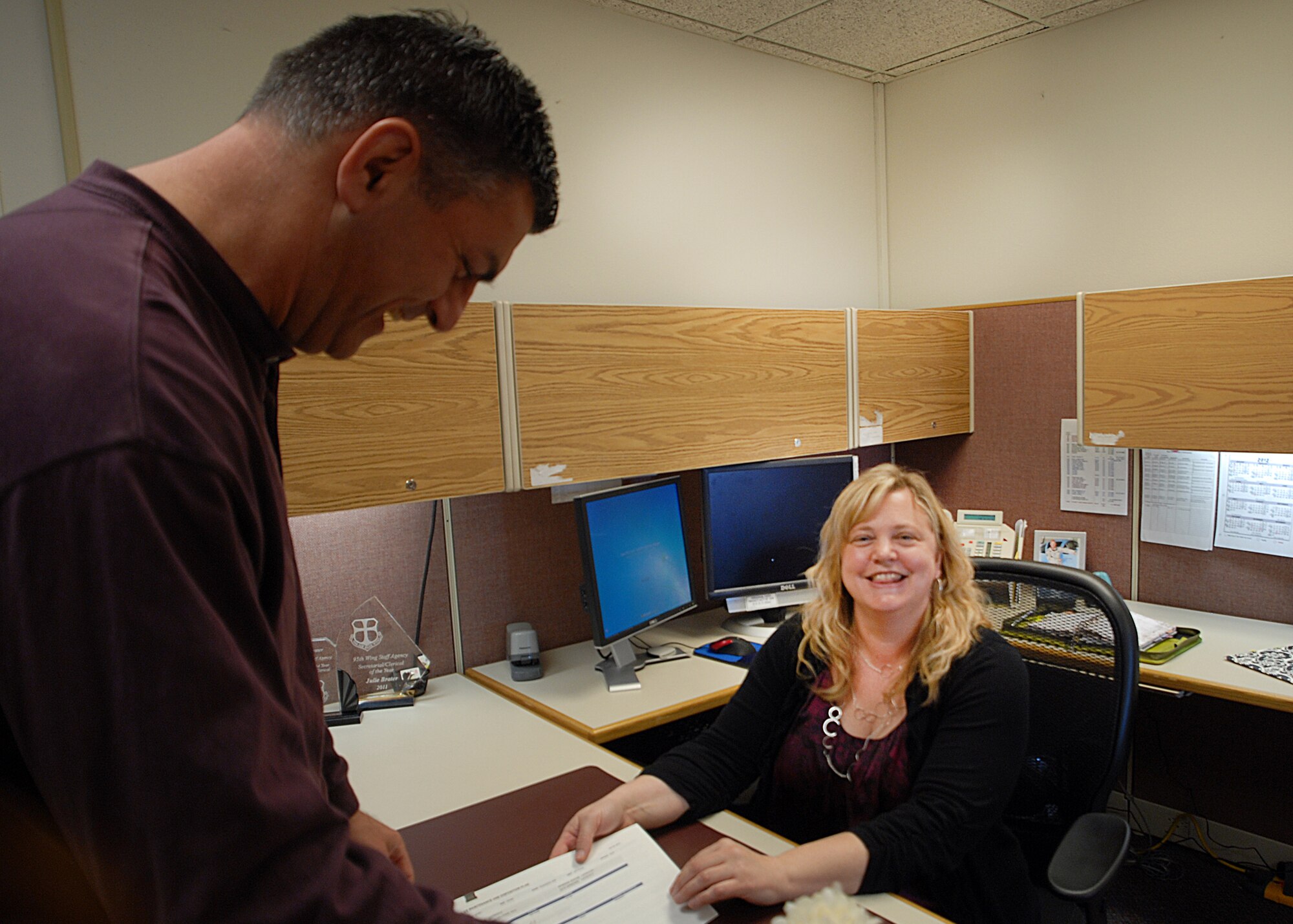 Julie Brater, Air Force Flight Test Center Safety Office secretary to the chief of Safety, and Bill Koukourikos, AFFTC Safety deputy chief, review a document and share a laugh in the Flight Safety building, Feb. 23. Brater was selected as the Air Force Materiel Command’s 2011 nominee for the 8th Annual Department of Defense David O. Cooke Excellence Award in Public Administration. (U.S. Air Force photo by Kate Blais)