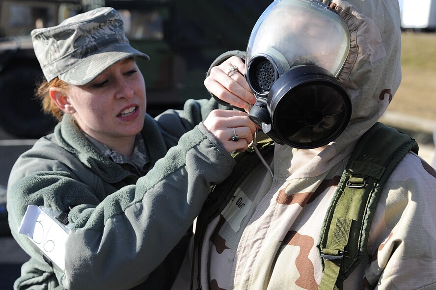 Air Force Staff Sgt. Stephanie Pileggi, assigned to the 375th Civil Engineer Squadron, demonstrates how to properly secure protective overgarments as part of chemical warfare readiness training during an Operational Readiness Exercise held on Scott Air Force Base Feb. 21-25, 2012. OREs are designed to test the base’s ability to conduct operations in a deployed environment. (U.S. Air Force photo by Master Sgt. Dave DeRemer/Released)
