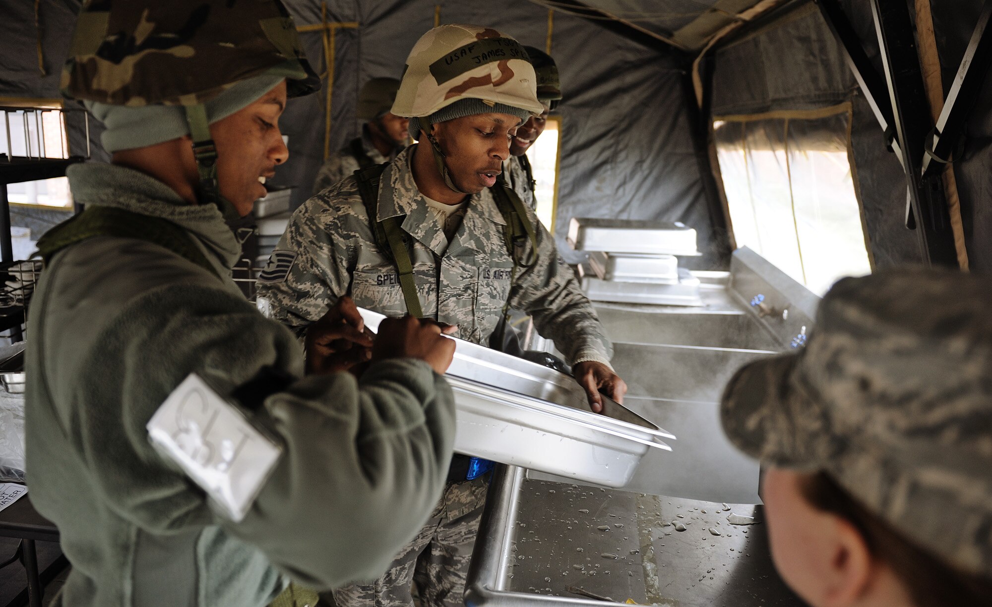 Tech. Sgt. James Speight, 375th Force Support Squadron food service technician, works with his team to clean and sanitize serving trays at the deployed dining facility at "Base X" during the base's Operational Readiness Exercise held Feb. 21-25, 2012. The dining facility provided a little comfort in the form of one hot meal each day, serving over 150 personnel. OREs are designed to test the base’s ability to conduct operations in a deployed environment. (U.S. Air Force photo by Staff Sgt. Ryan Crane)

