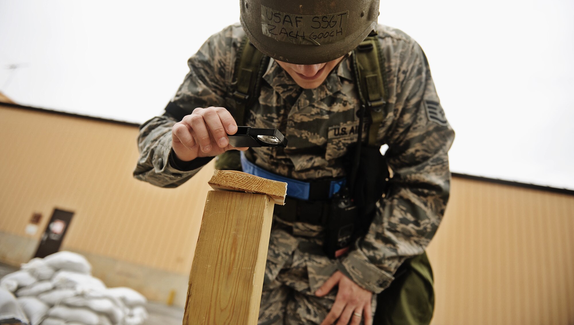 Air Force Staff Sgt. Zach Gooch, assigned to the 375th Force Support Squadron, uses a magnifying glass to identify possible contamination on a detection stand following a simulated mortar attack at “Base X” during an Operational Readiness Exercise held on Scott AFB Feb. 21-25. The ORE was designed to test the base’s ability to conduct operations in a deployed environment. (U.S. Air Force photo by Staff Sgt. Ryan Crane/Released)
