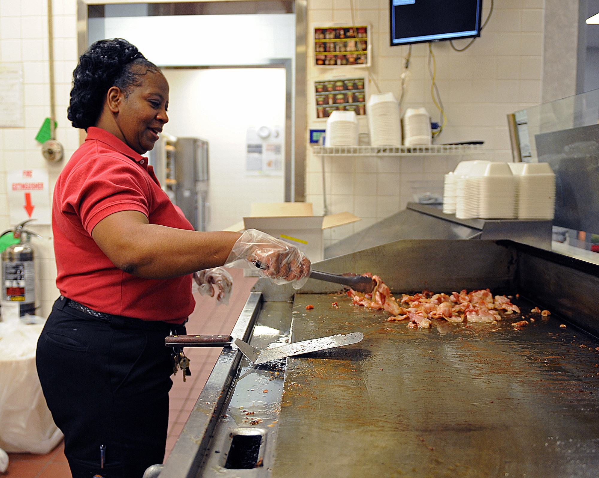 Lendoria Stanton, Army and Air Force Exchange Service food court manager, cooks bacon in The Exchange at Barksdale Air Force Base, La., Feb. 23. AAFES managers, like Airmen, can go on temporary duty to bases and posts overseas. (U.S. Air Force photo/Airman 1st Class Micaiah Anthony)(RELEASED)
