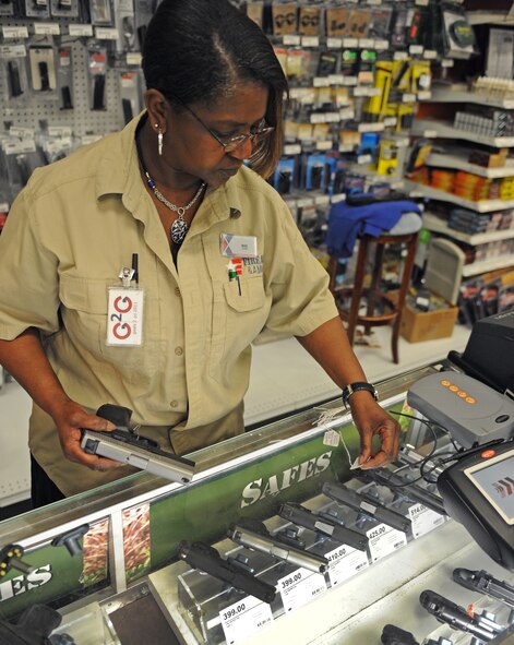 Mae Henderson, Army and Air Force Exchange Service employee, places tags on hand guns in The Exchange at Barksdale Air Force Base, La., Feb. 23. All firearms are removed from their glass cases and stored in a safe overnight. In the morning, sales associates place the firearms back in their cases and ensure that all of the weapons are accounted for. (U.S. Air Force photo/Airman 1st Class Micaiah Anthony)(RELEASED)