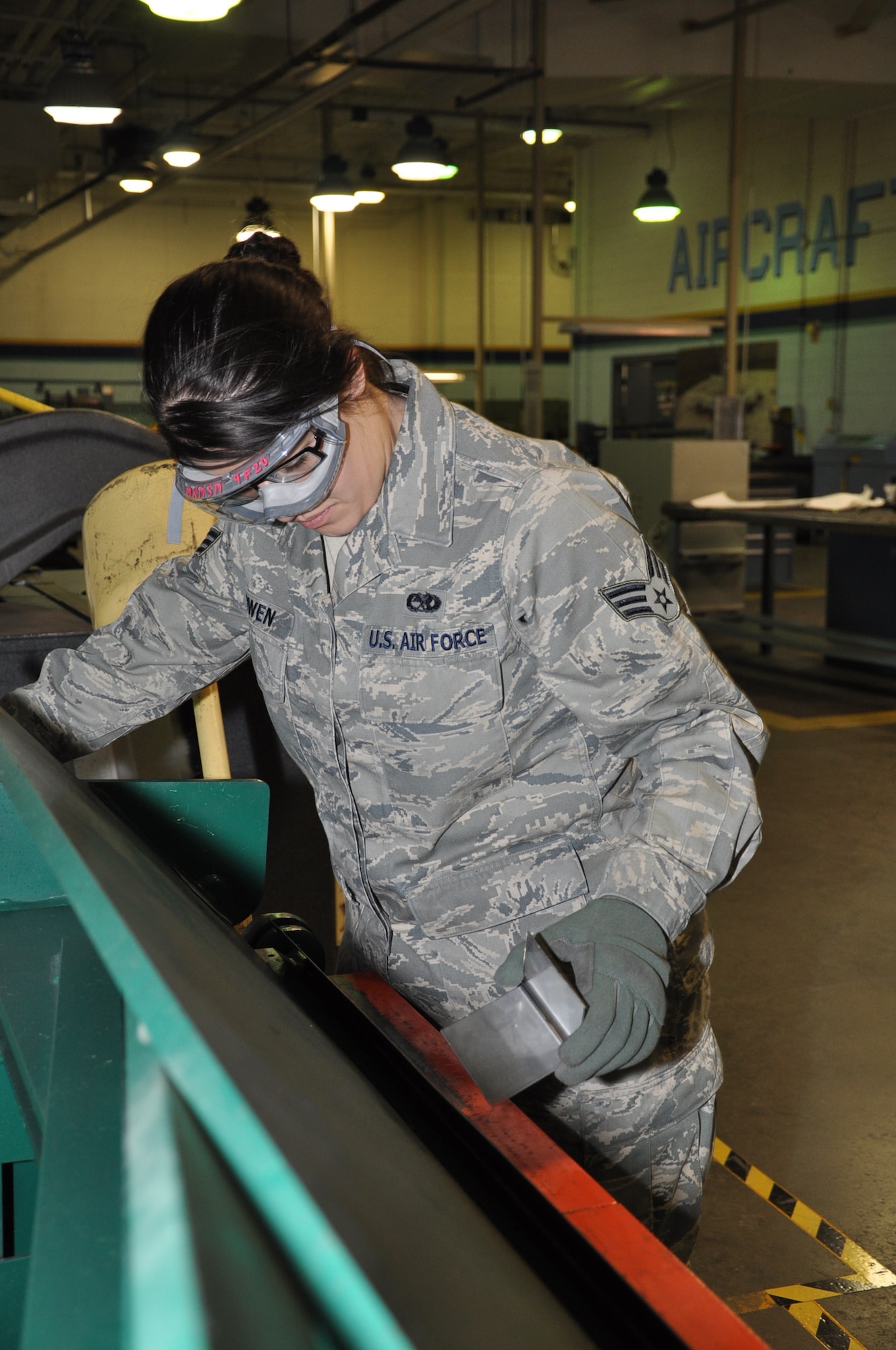 Senior Airman Emilie Owen, aircraft structures specialist, 931st Maintenance Squadron, uses a cornice brake to bend a steel gusset for an aircraft galley. The gusset is a type of bracket that secures two aluminum sides of the galley. After the steel is bent to create the gusset, it will be cut and sanded into the proper shape. (Official photo by Tech. Sgt. Brannen Parrish) 