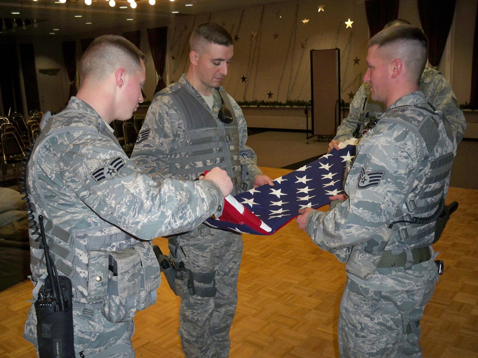 Members of the Alaska Air National Guard 213th Space Warning Squadron perform a flag folding ceremony at Clear Air Force Station, Alaska, to replace a flag burnt in a house explosion in Kansas Aug. 23, 2011. The home belonged to Annette Cook, a childhood friend of Alaska Air National Guard Tech. Sgt. Ricky Ramos, from Clear Air Force Station. Ramos was spurred into action to help the Cook family after seeing pictures of the destruction online. After months of research and raising money, Ramos and his unit were able to replace the Purple Heart and burnt flag, and put it into a new shadow box to be displayed at the Cook family’s new home. (U.S. Air Force photo)