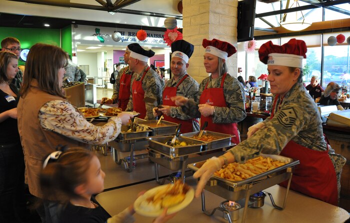 First sergeants of Team Beale serve families of deployed Airmen during the Hearts Apart dinner at the Contrails Dining Facility at Beale Air Force Base, Calif., Feb. 15, 2012. The dinner hosted by the Airman and Family Readiness Center to have spouses and families of deployed Airmen to meet and have a meal. (U.S. Air Force photo by Staff Sgt. Robert M. Trujillo/Released)