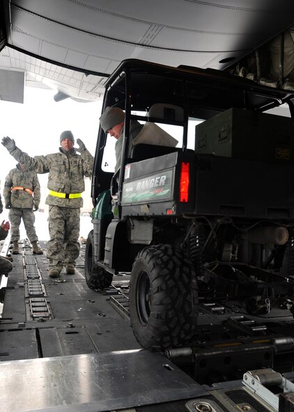 Tech. Sgt. Kevin Reiter, left, and Airman 1st Class Grant Gleason, members of 319th Logistics Readiness Squadron, load an all terrain vehicle into a C-130 Hercules after it touched down on the flight line on Grand Forks Air Force Base, N.D., Feb. 22, 2012. The arrival of the aircraft allowed Airmen from the 319th Logistics Readiness Squadron to take part in training scenarios designed to help them develop their skills and gain more experience on correctly loading and unloading cargo on and off live aircraft. (U.S. Air Force photo/Senior Airman Amber Bennett)