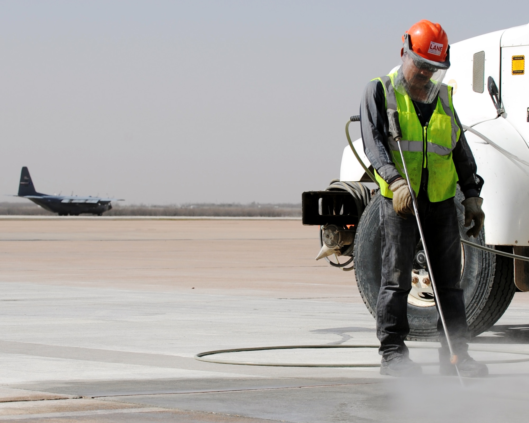 Mr. Pablo Cruz power washes the taxi-way Feb. 22, 2012, preparing it for repairs, at Dyess Air Force Base, Texas. The taxi way shoulder repair project is estimated to be finished March 12, 2012 and cost approximately $1.7 million. (U.S. Air Force photo by Airman 1st Class Jonathan Stefanko/ Released)